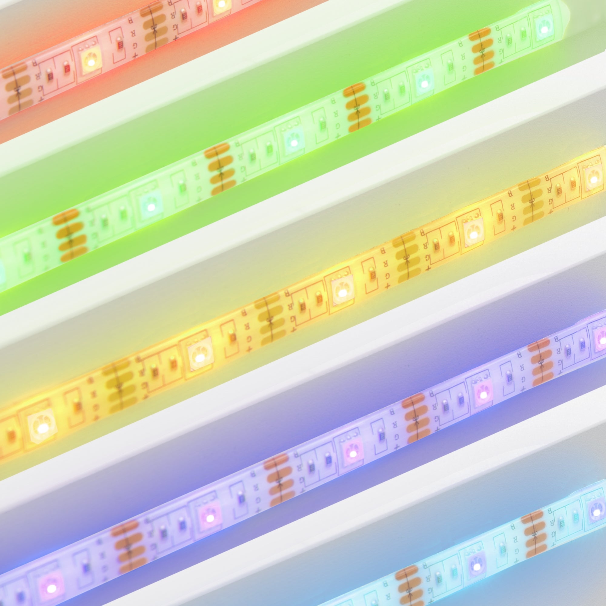 Bunte LED-Streifen in verschiedenen Farben auf einer weißen Oberfläche.
