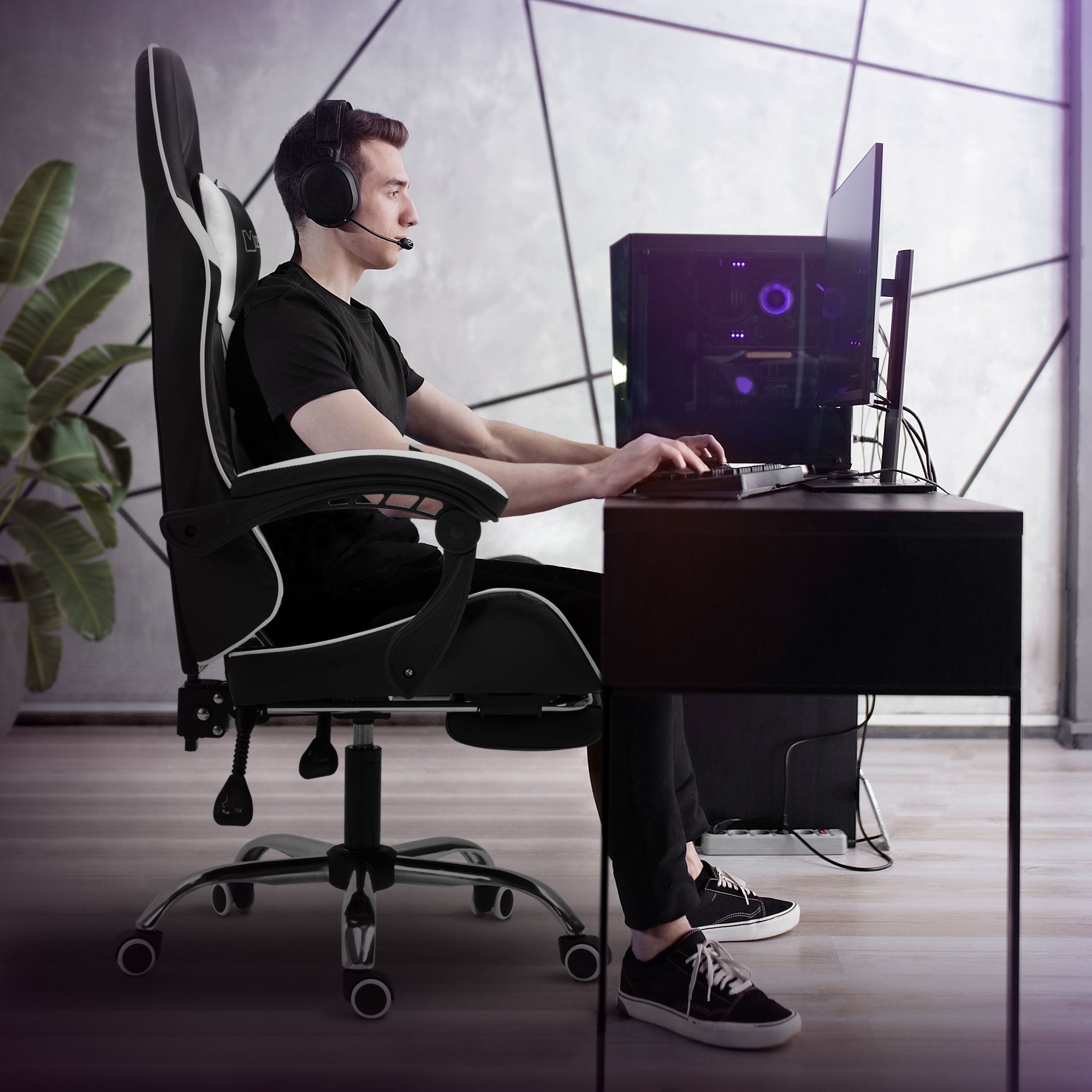 Hombre con auriculares sentado en un escritorio y usando una computadora.