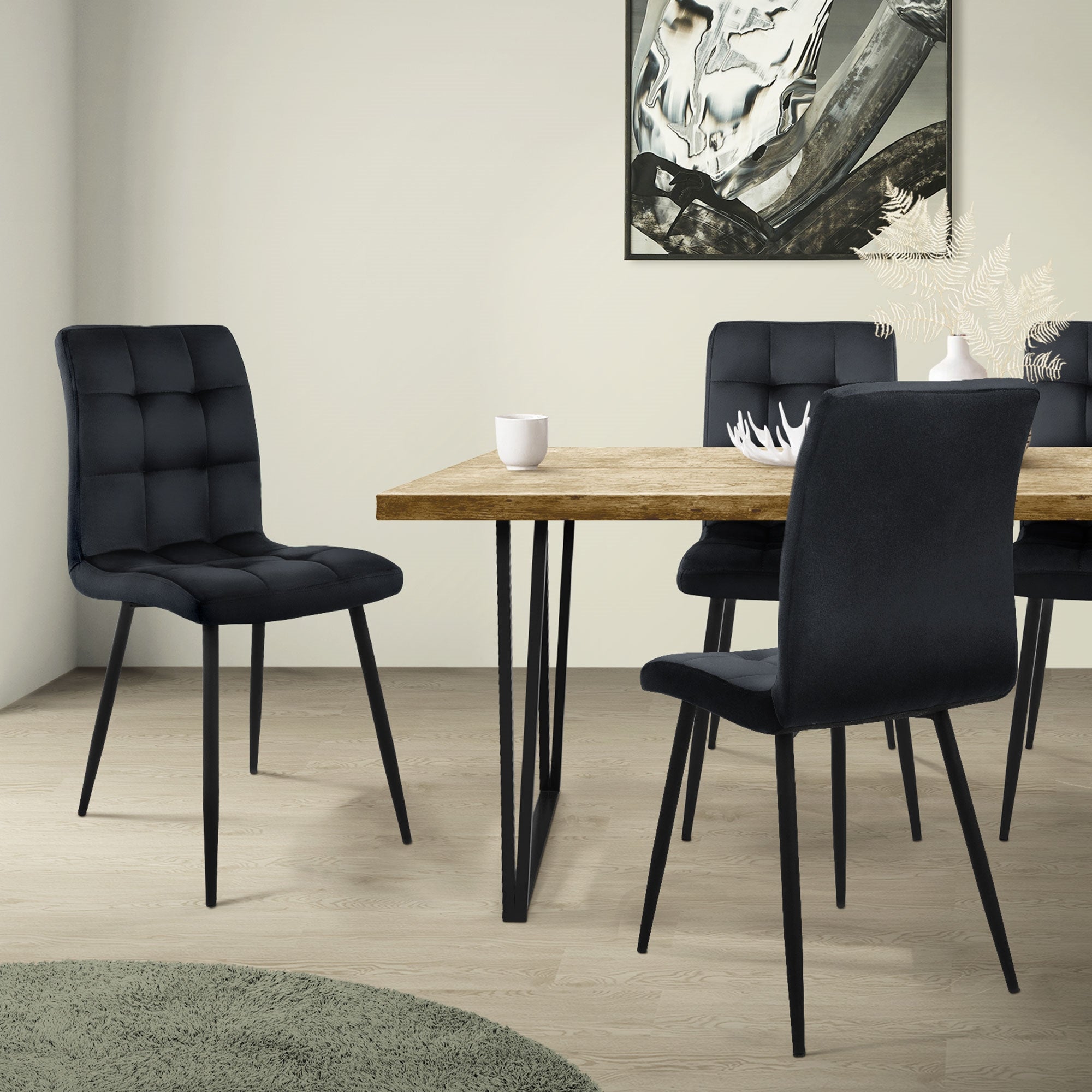 Une chaise noire est placée à une table avec un plateau en bois dans une pièce lumineuse.