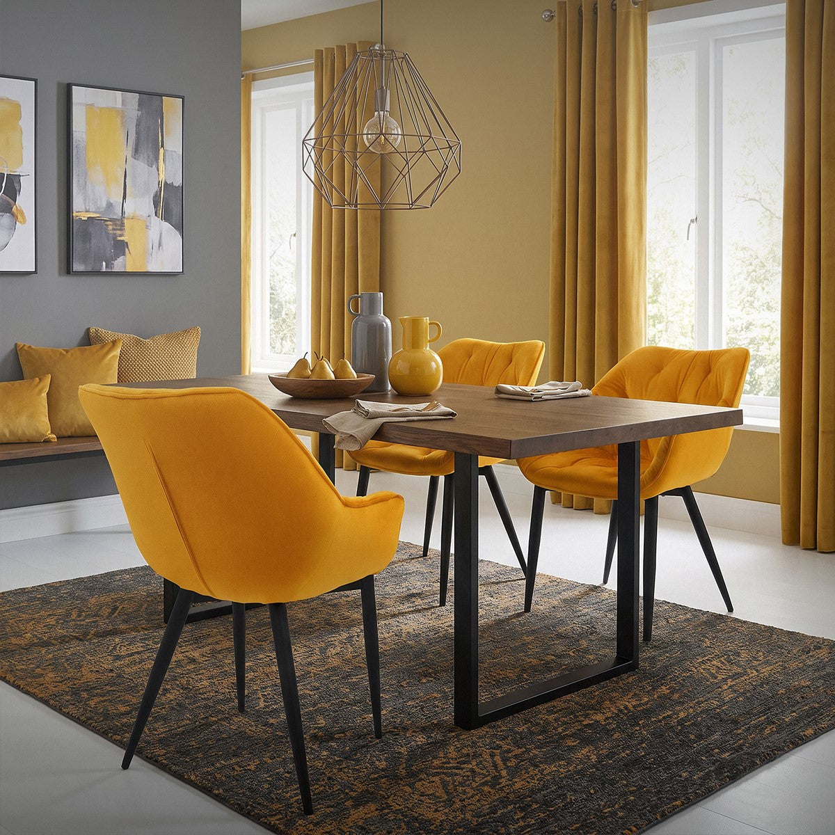 A dining room with a wooden table and yellow chairs, decorated with cushions.