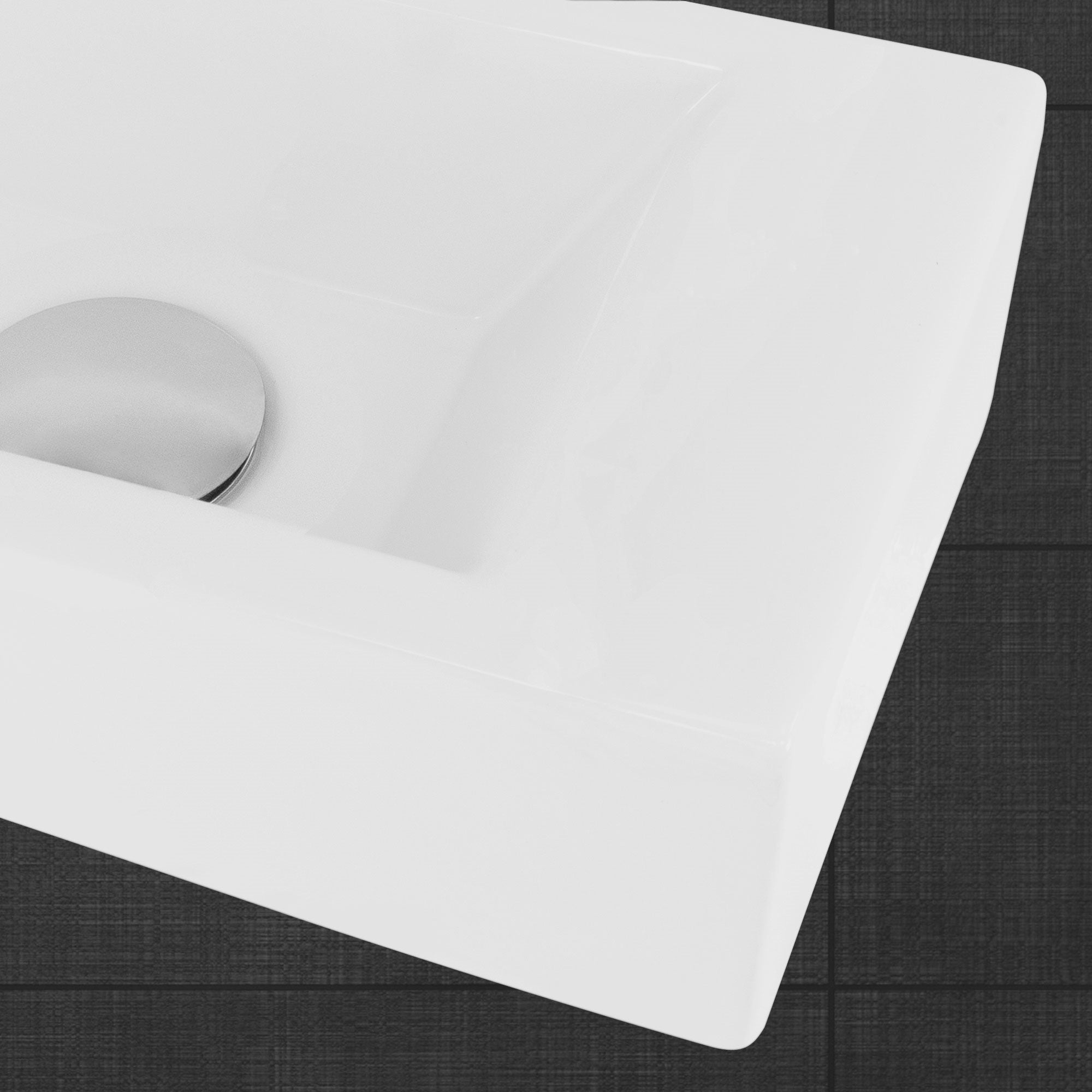 Close-up of a white sink with a round drain cover.