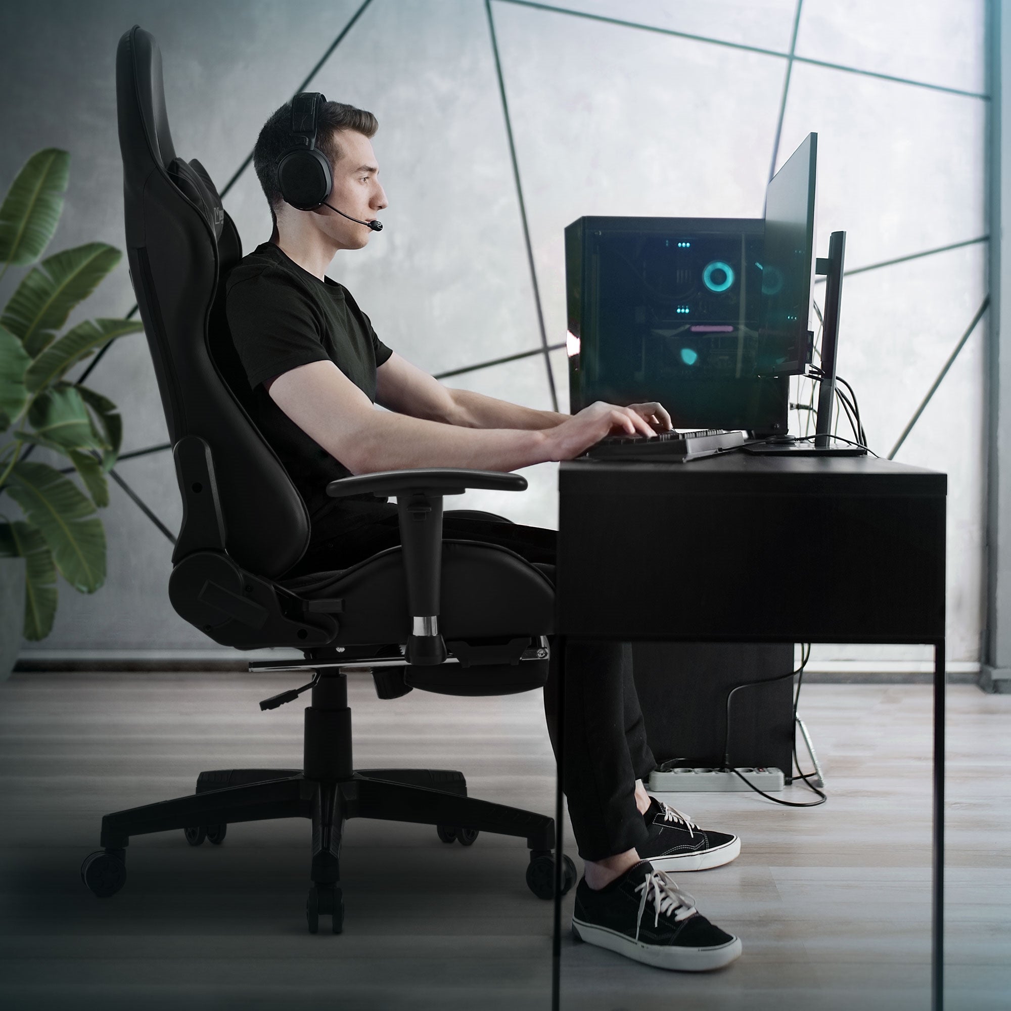 Man met headset zit aan een bureau in een gamingstoel.