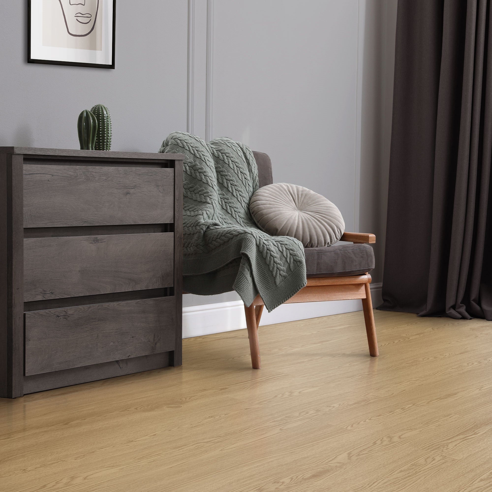 Una habitación acogedora con un sillón, una manta y una mesita de noche.