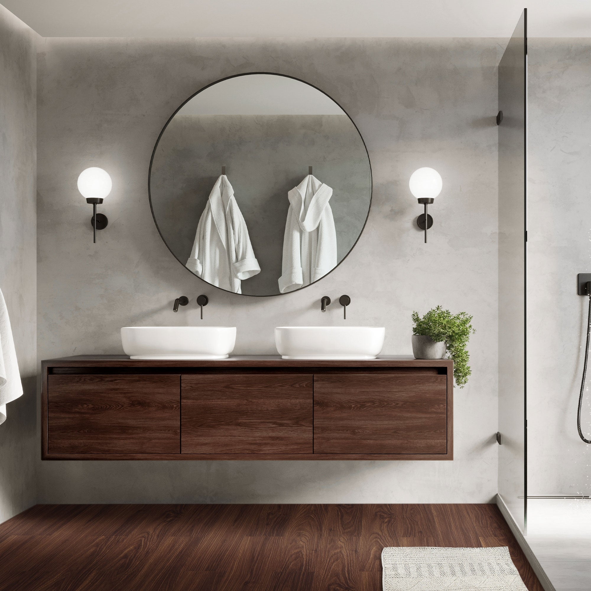 Bagno moderno con due lavandini, specchio rotondo e armadietto in legno.