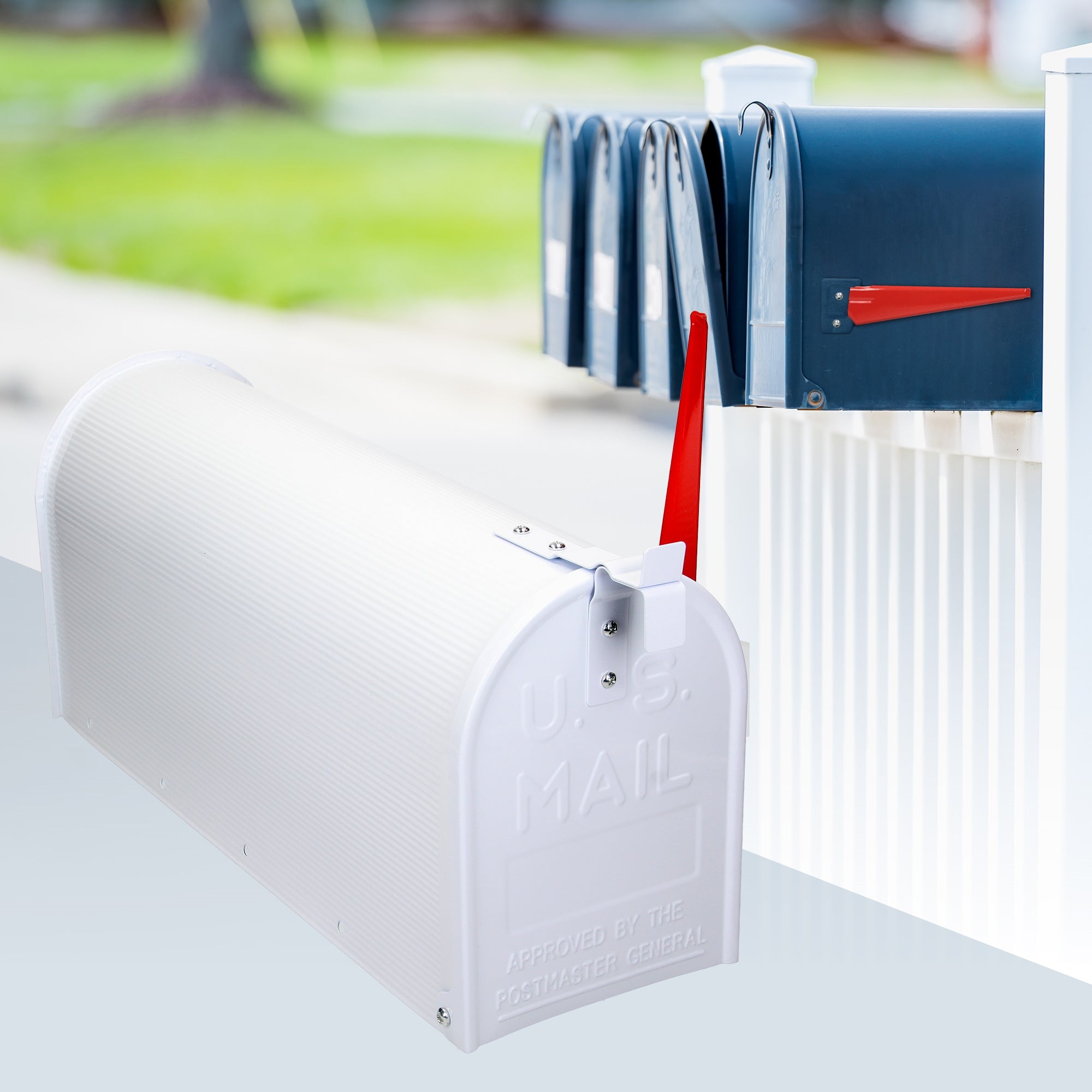 Boîte aux lettres blanche avec un drapeau rouge et plusieurs boîtes aux lettres en arrière-plan.