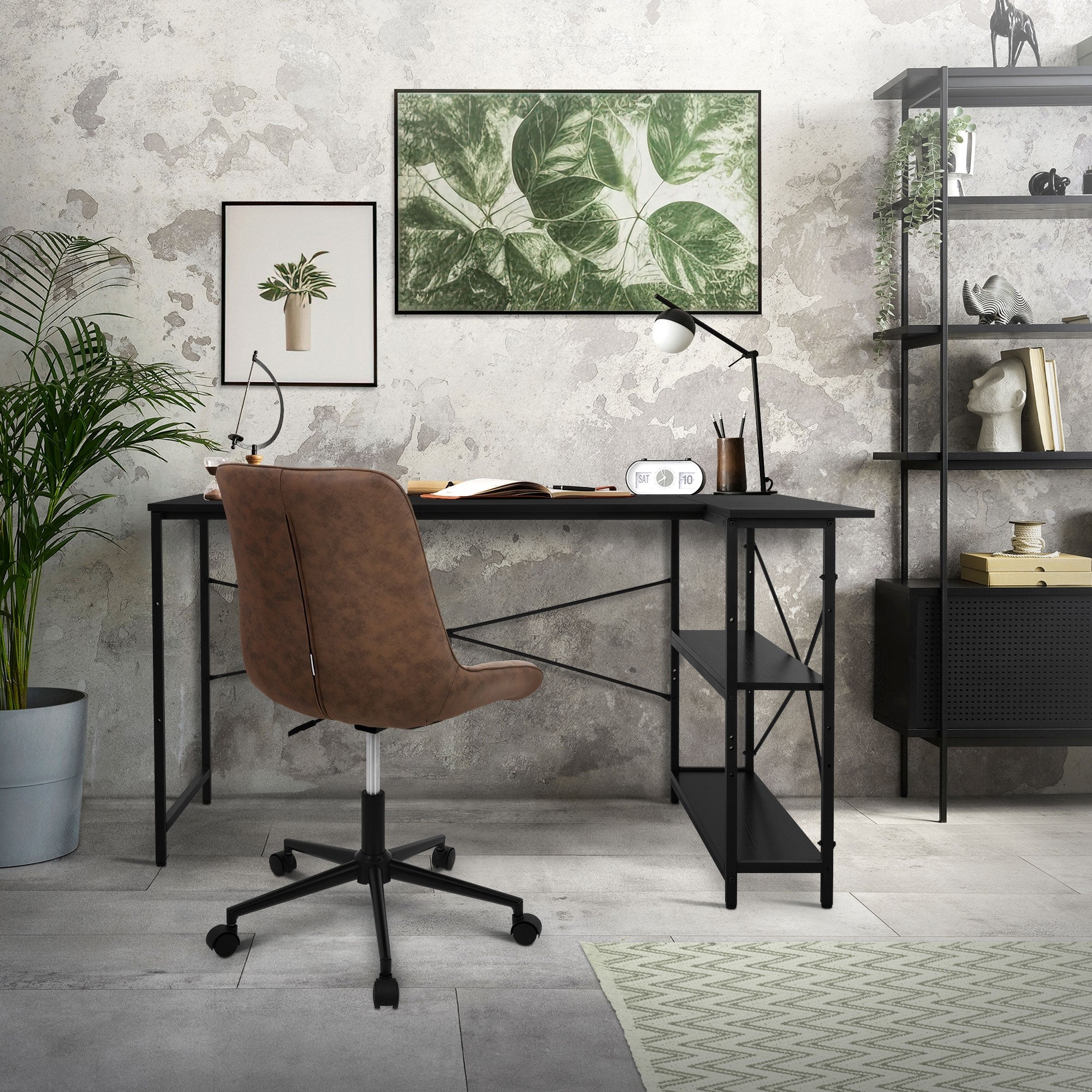 Desk in a room with plants and pictures on the wall.