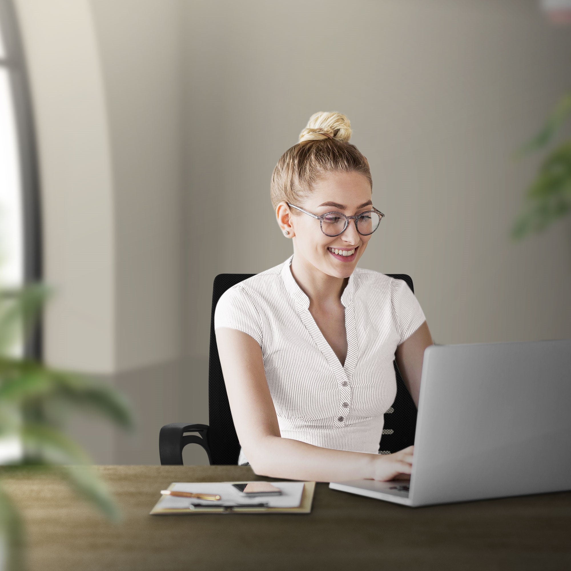 Vrouw glimlacht terwijl ze aan de laptop werkt, omringd door planten.