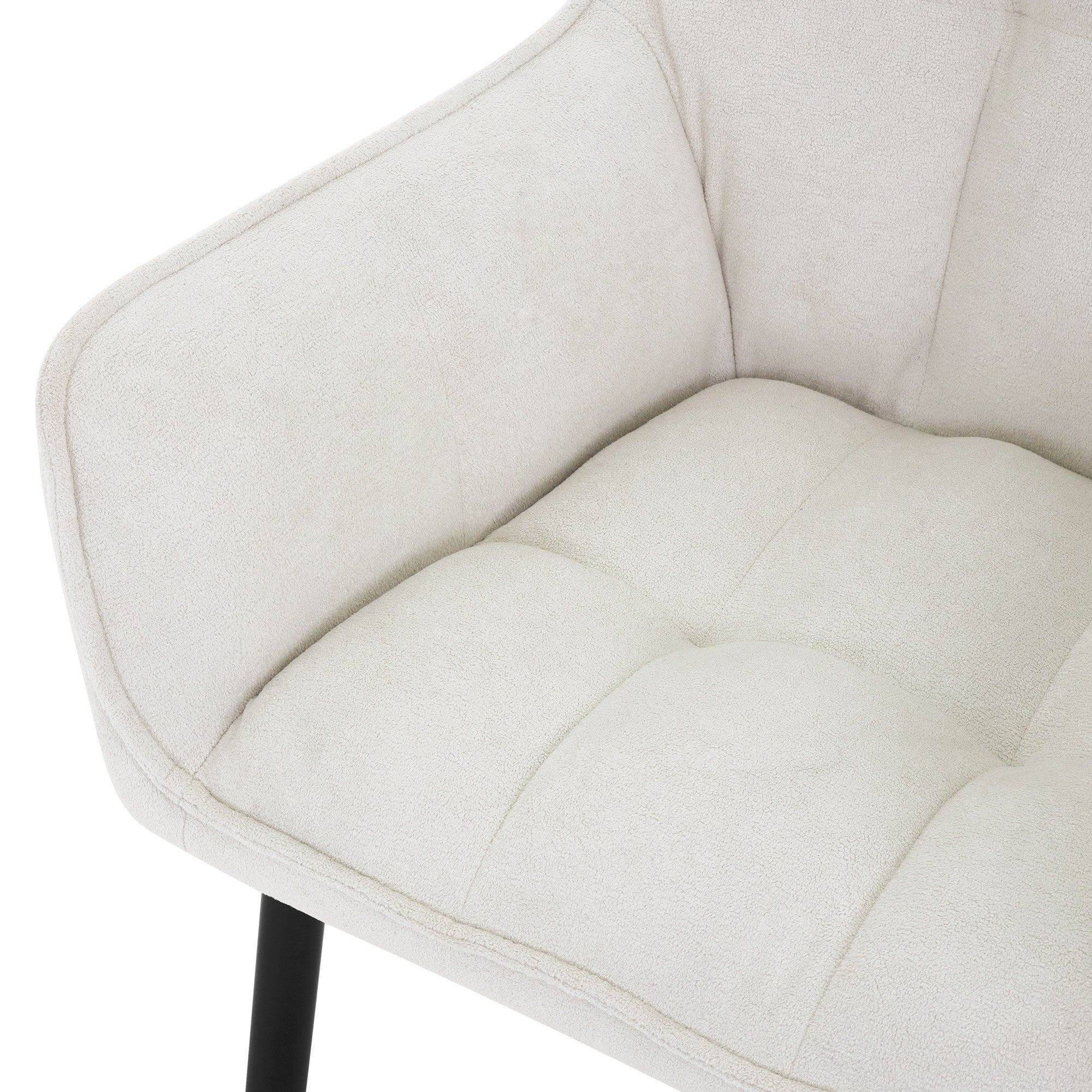 Primer plano de una silla color crema con asiento acolchado.
