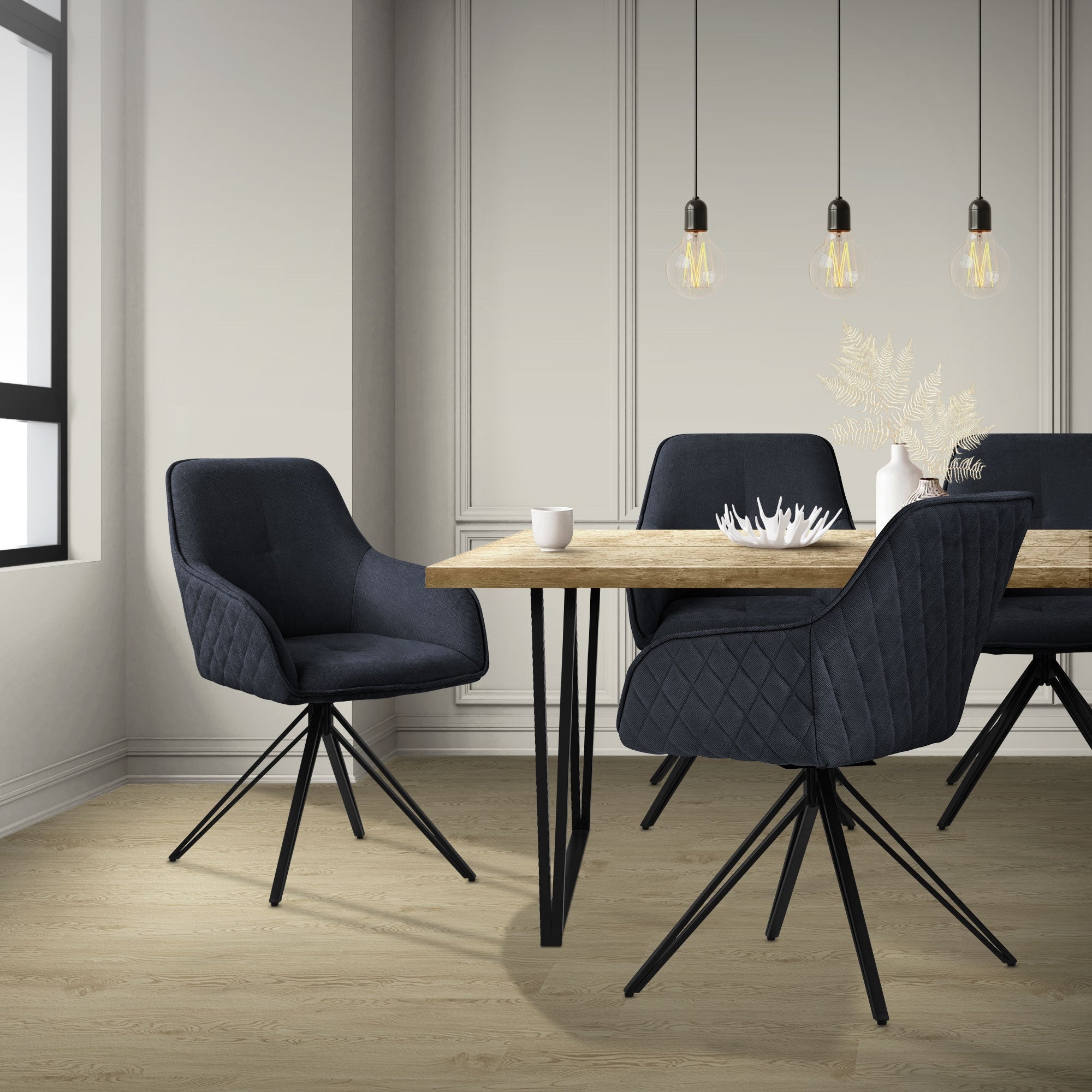 Ein Esszimmer mit einem Holztisch und vier schwarzen Stühlen.