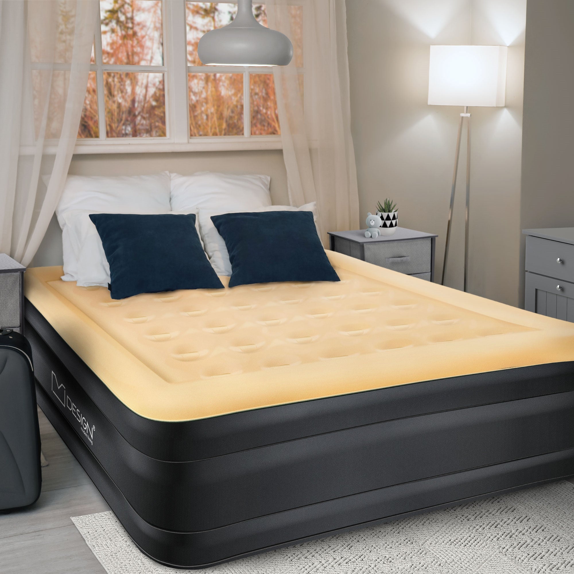 Luchtmatras in een slaapkamer met kussen en nachtkastje.