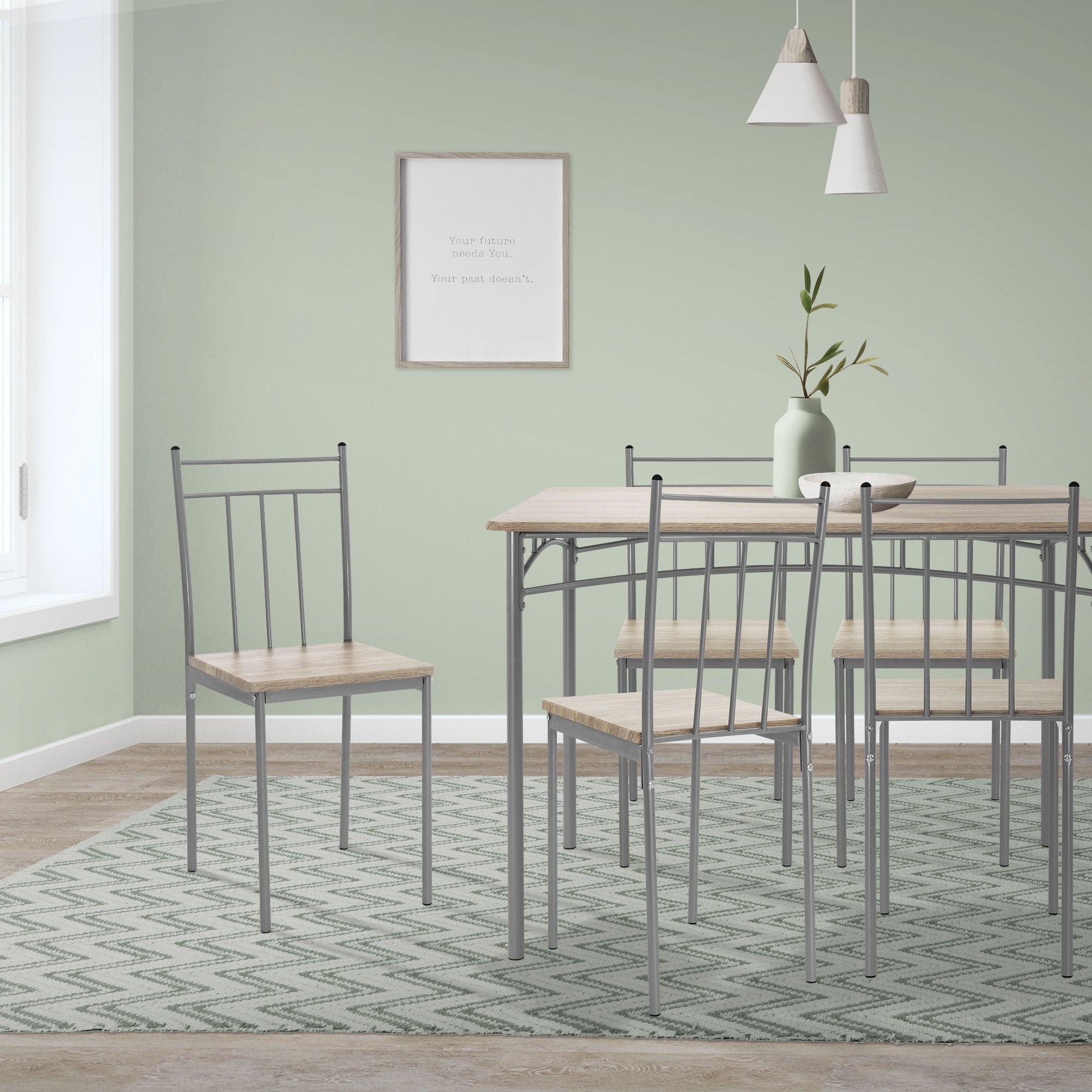 Área de comedor con una mesa, cuatro sillas y una pared verde.