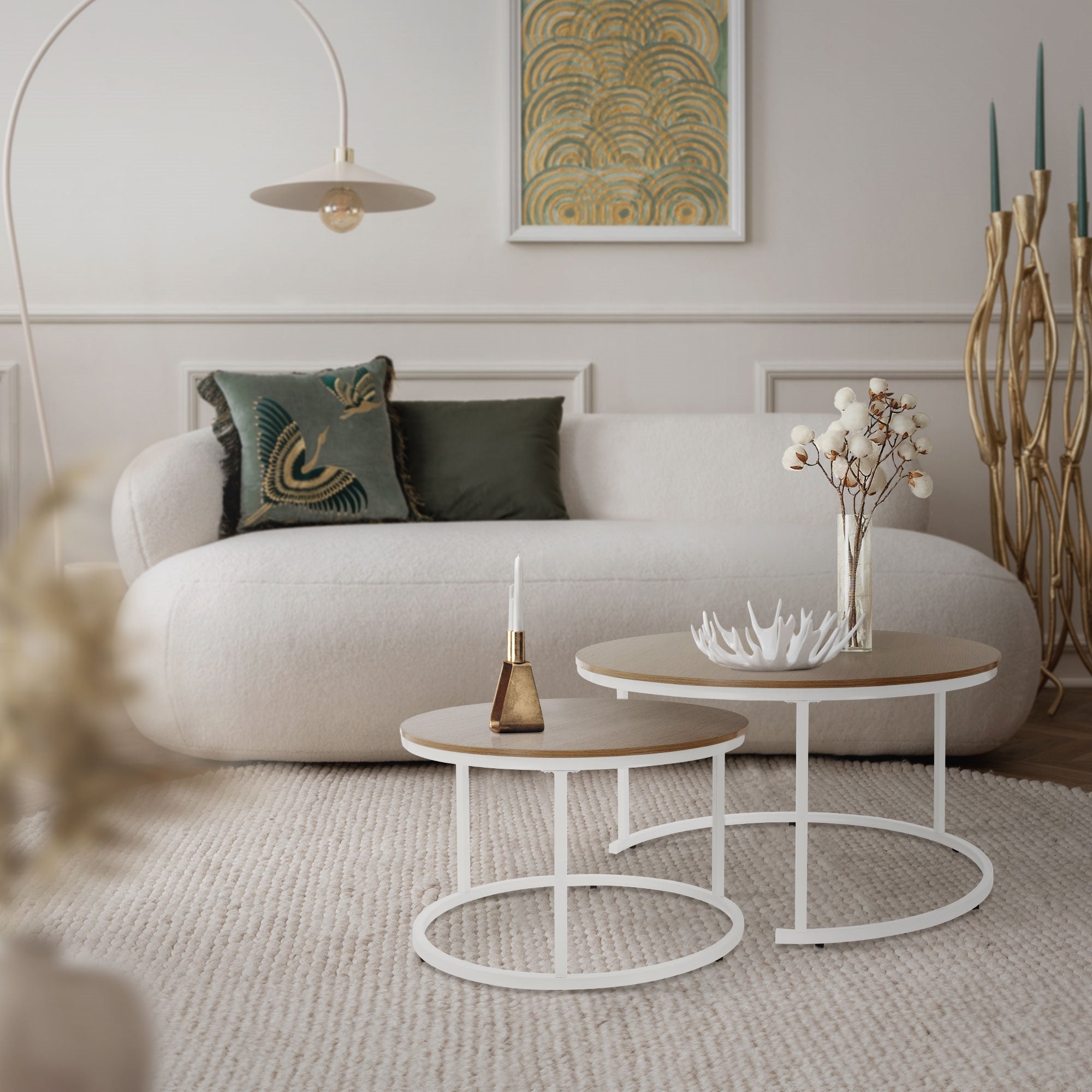 Salon avec un canapé blanc, des tables basses et une lampe sur pied.