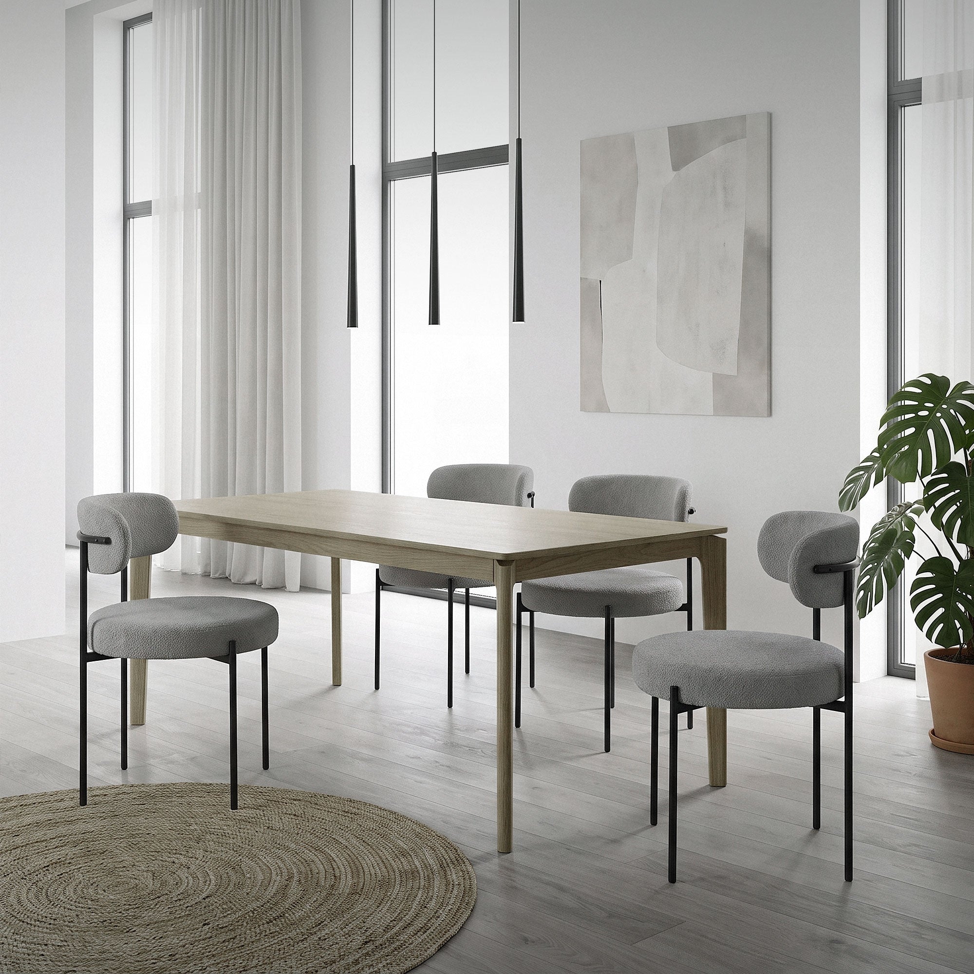 Una habitación luminosa con una mesa de madera, sillas grises y grandes ventanas.