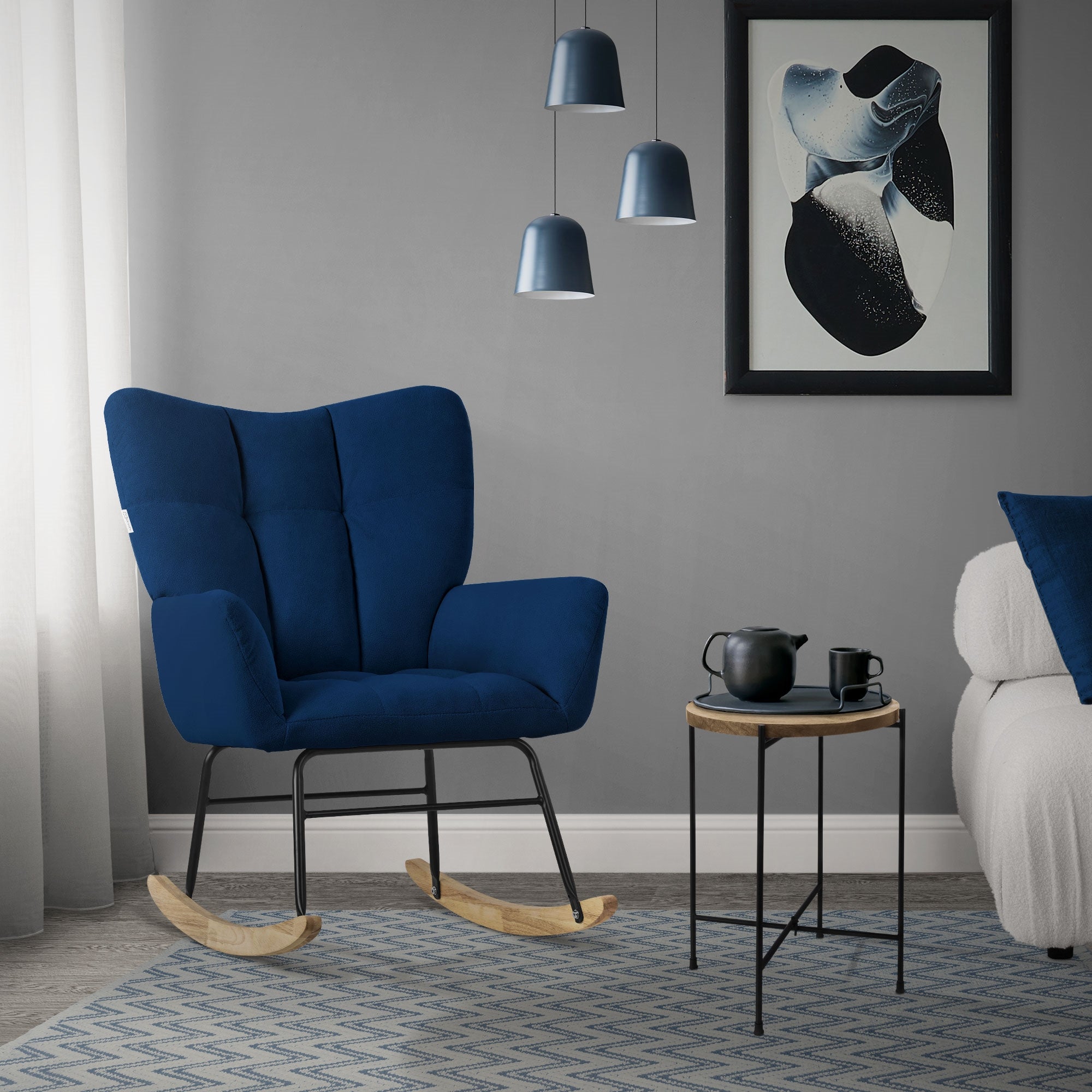 Ein blauer Schaukelstuhl neben einem kleinen Tisch und einer Lampe.