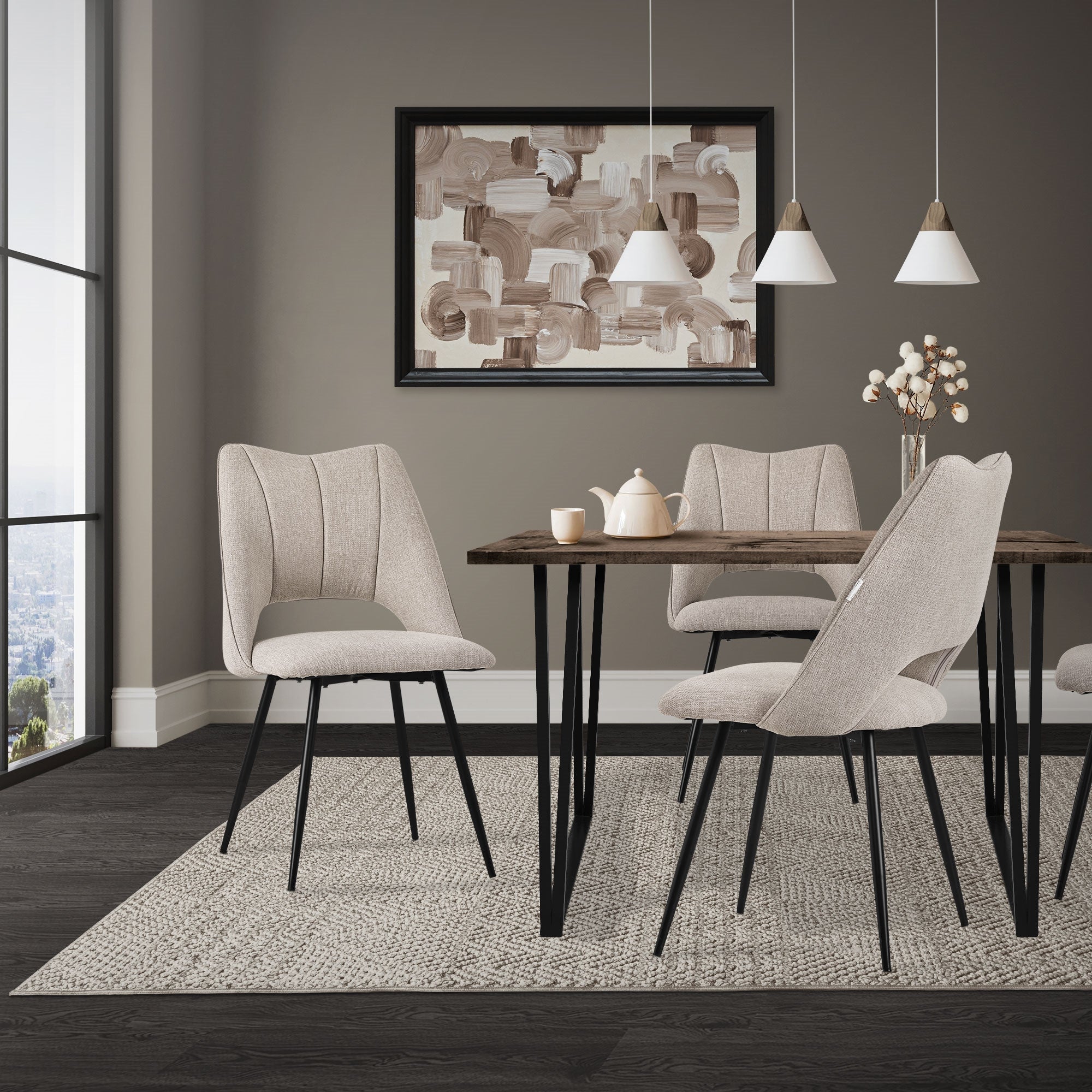 Un comedor con una mesa y cuatro sillas grises, una pintura en la pared.