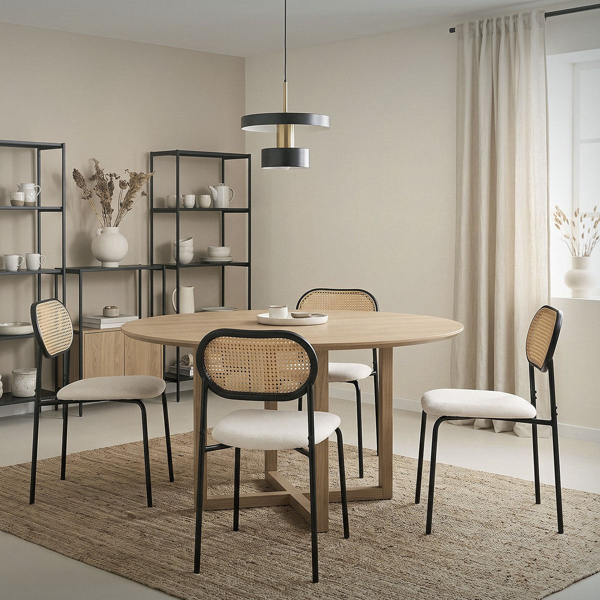 Ein moderner Essbereich mit runder Holztafel und vier Stühlen auf einem Teppich.