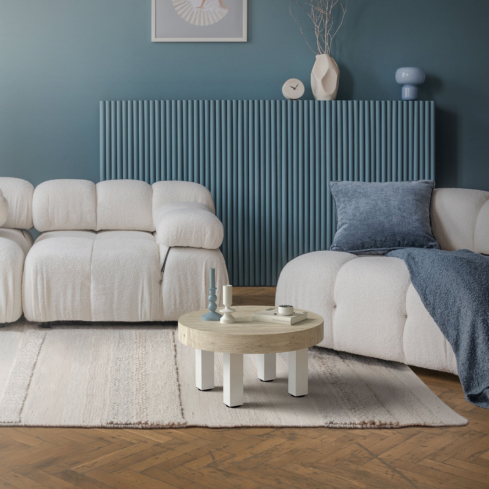 Sala de estar con una mesa redonda, dos sofás y elementos decorativos.