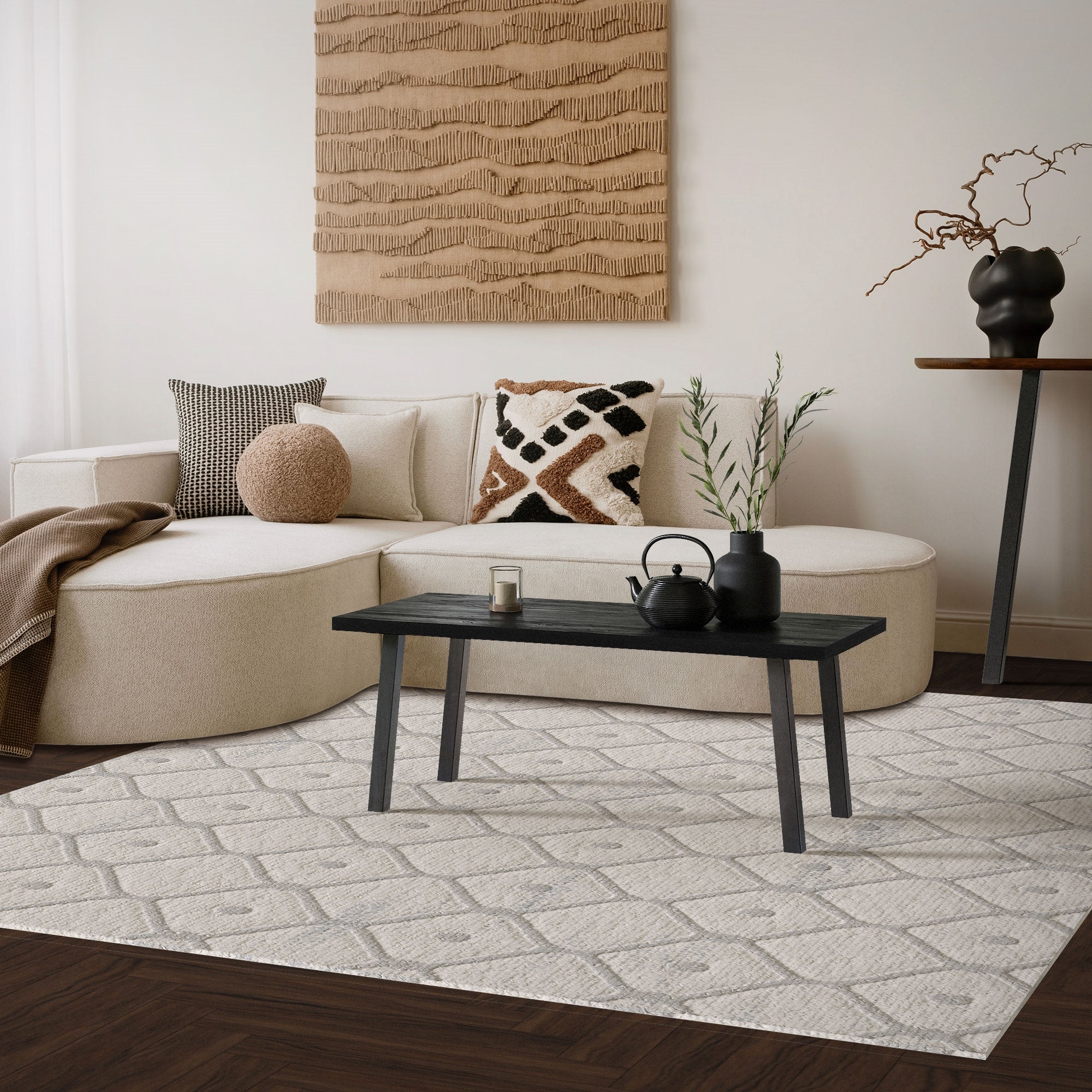 Heller Wohnraum mit Sofa, Tisch und Dekoration auf einem Teppich.