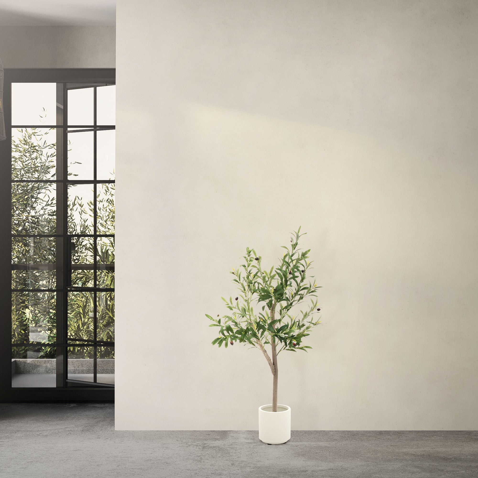 Künstlicher Baum in einem weißen Topf vor einer Wand.
