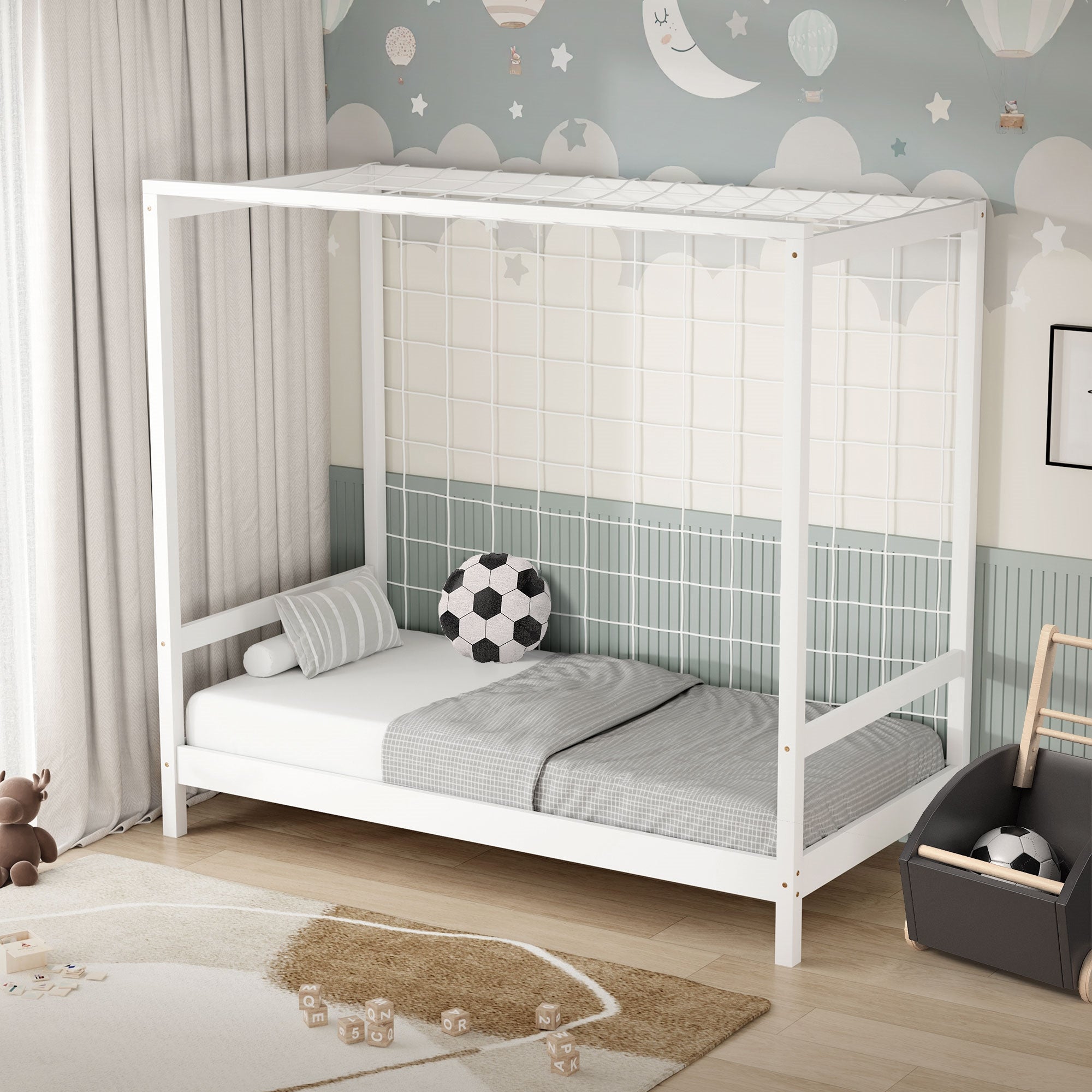 Una cuna de madera con una sábana de cama gris y un balón de fútbol en el colchón.