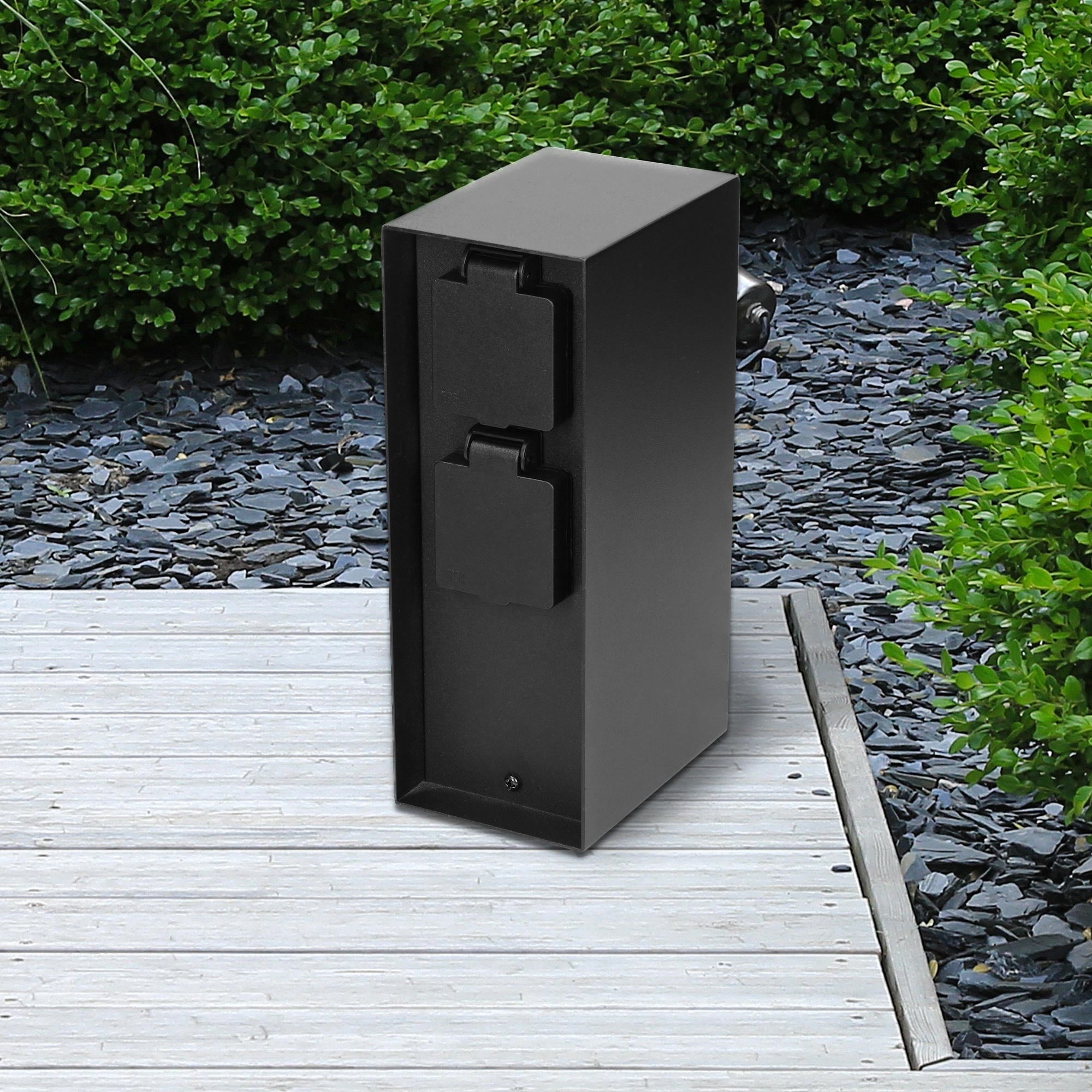 Black box on wooden deck with stones in the background.