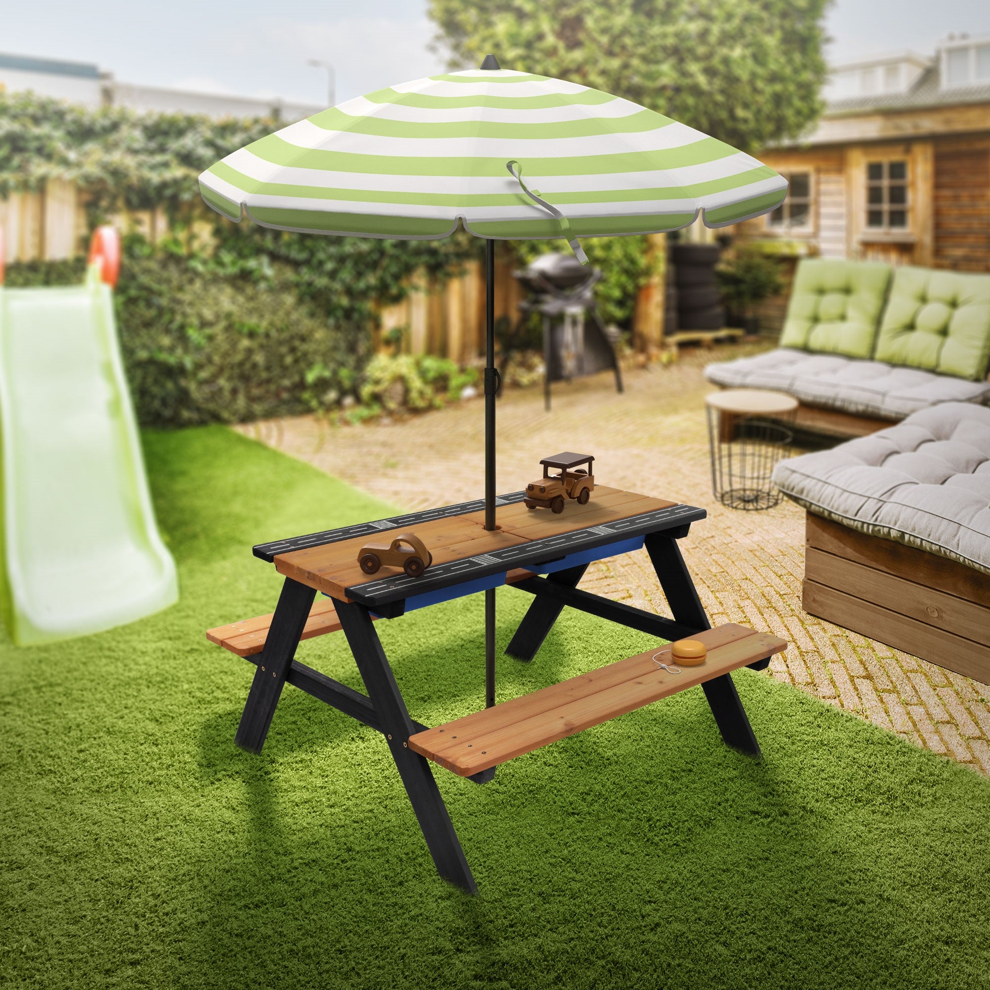 Gartenbereich mit Tisch, Bänken und Sonnenschirm.