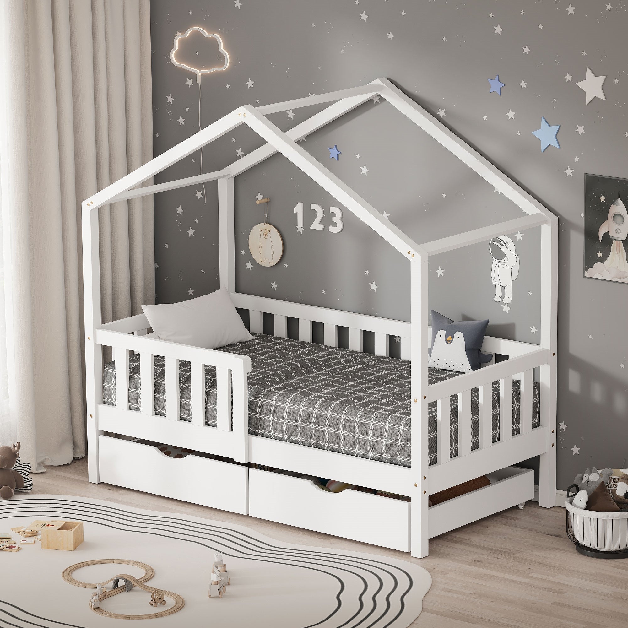 Ein weißes Kinderbett in Hausform mit grauer Bettwäsche und Wanddekoration.