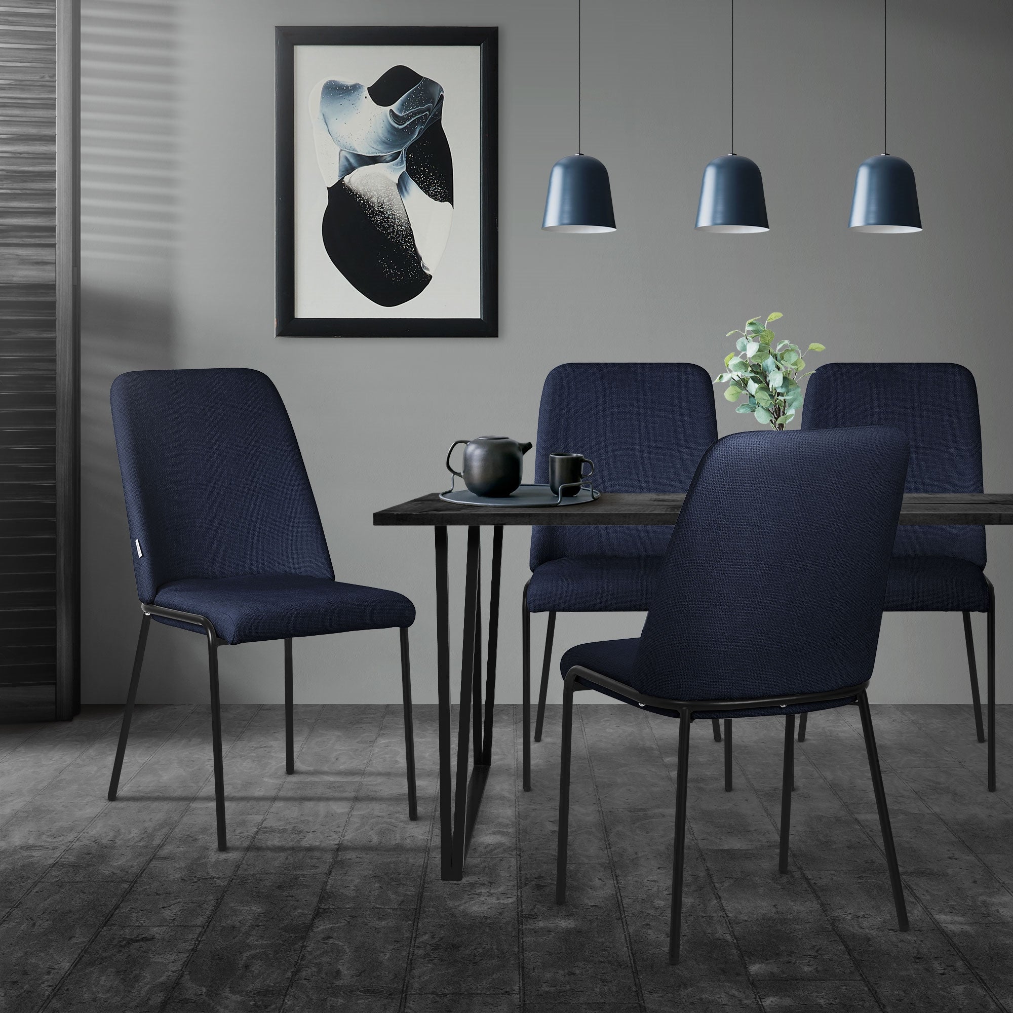 Eetruimte met vier donkerblauwe stoelen en een tafel, versierd met planten.