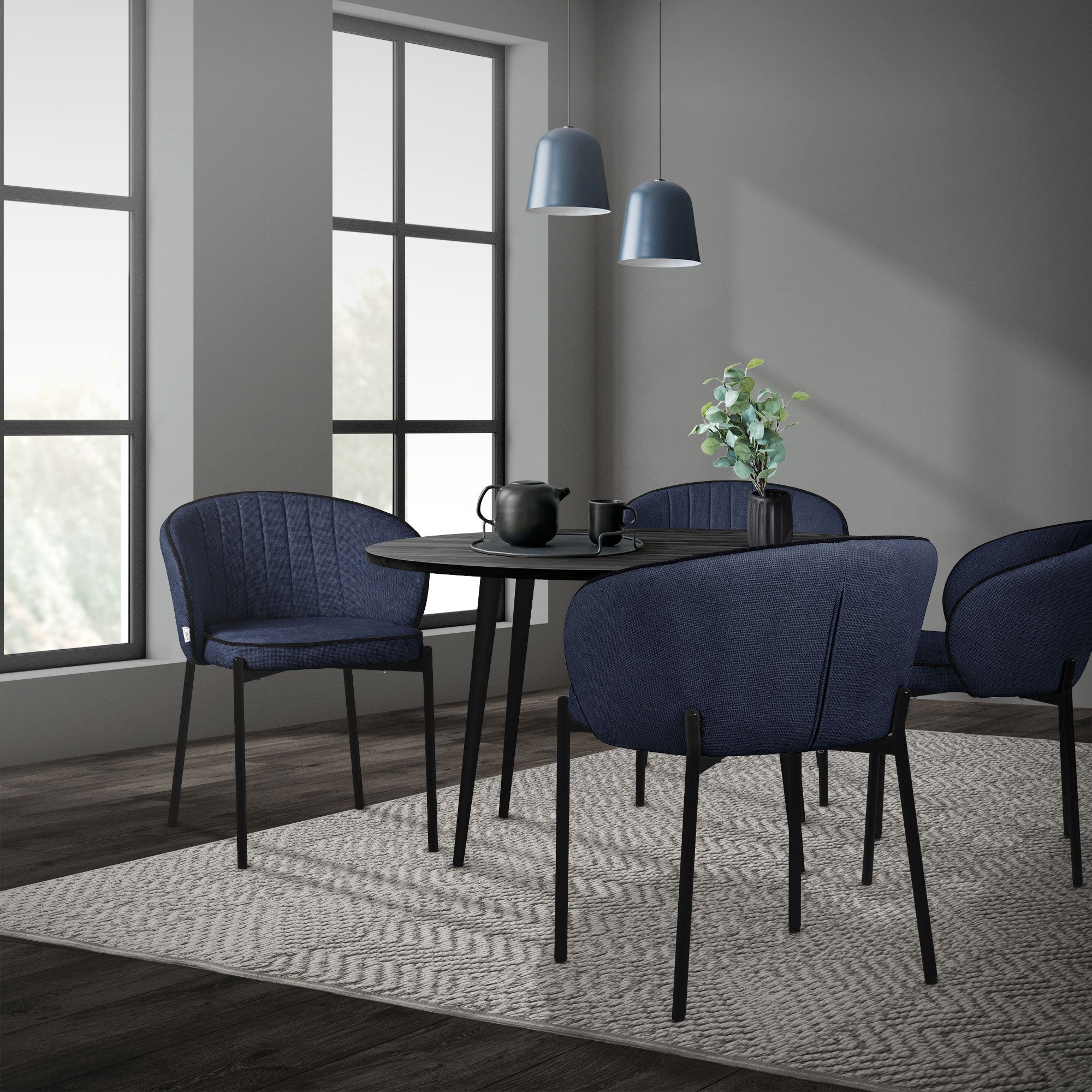 Sala da pranzo con un tavolo rotondo e quattro sedie blu.