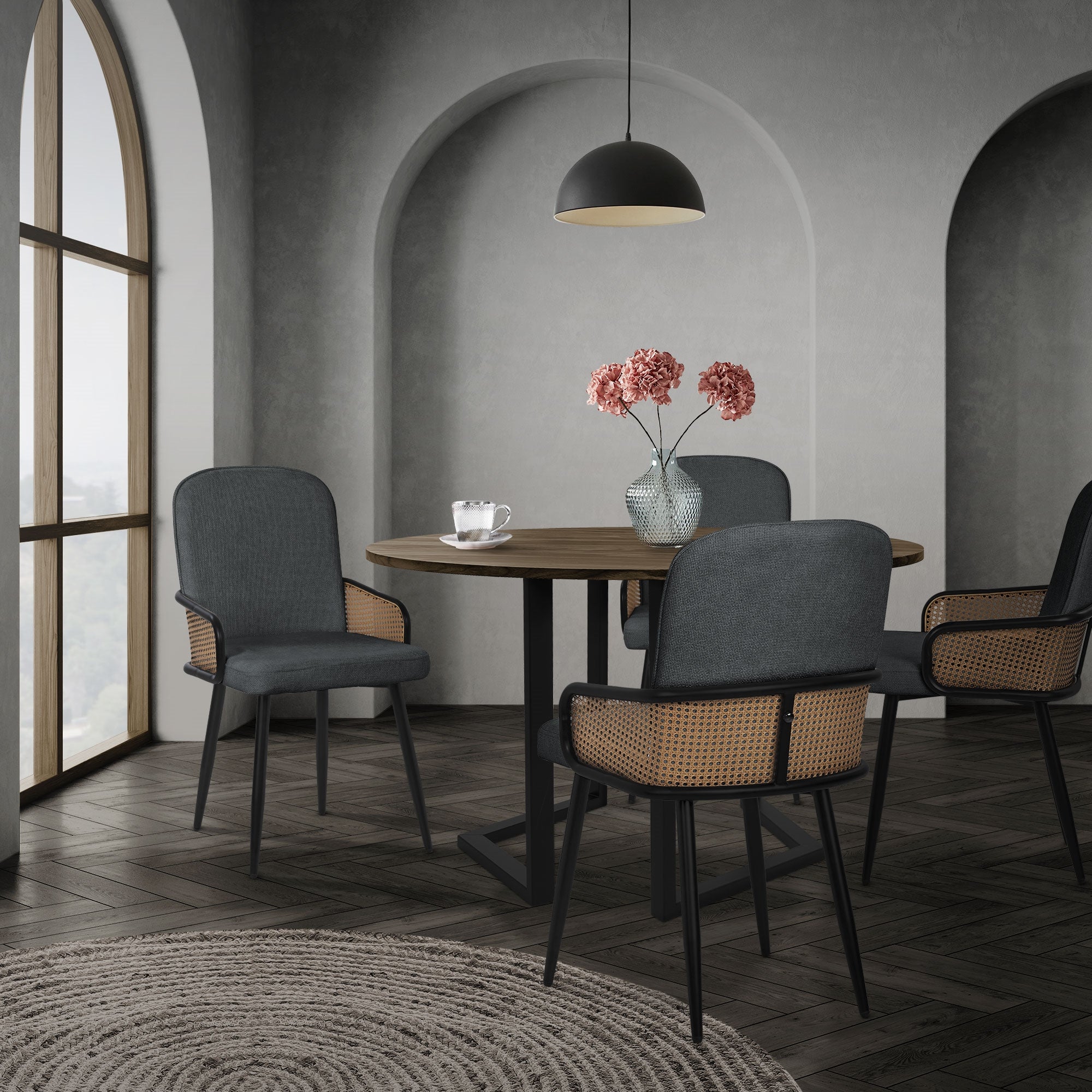 Eetruimte met een ronde tafel, vier stoelen en een vaas met bloemen.