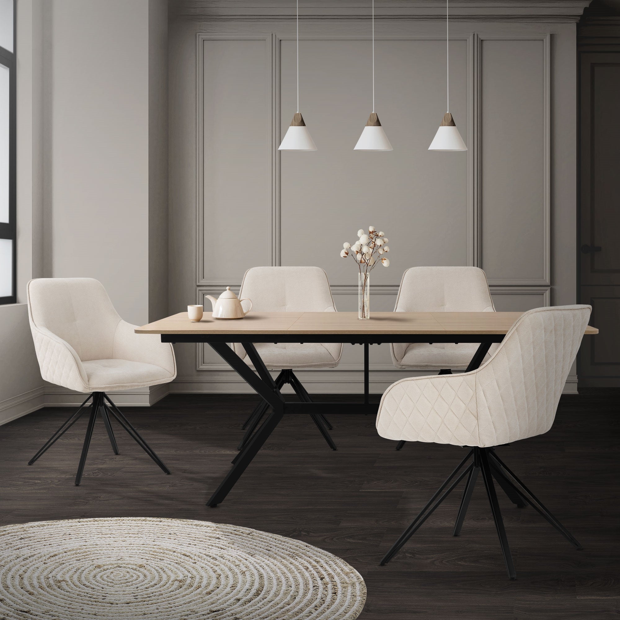 Salle à manger avec une table en bois et quatre chaises blanches, éclairée par trois lampes suspendues.