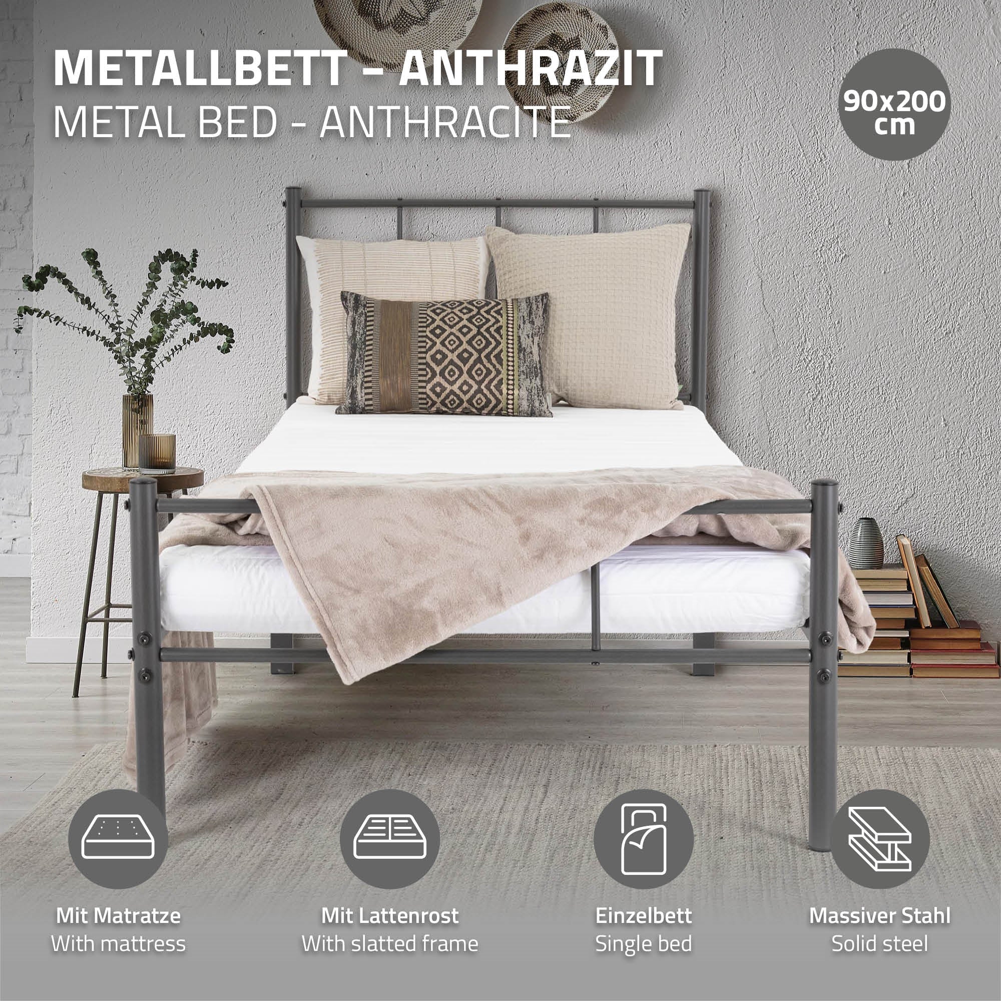 Lit en métal anthracite avec matelas et coussin sur un sol clair.