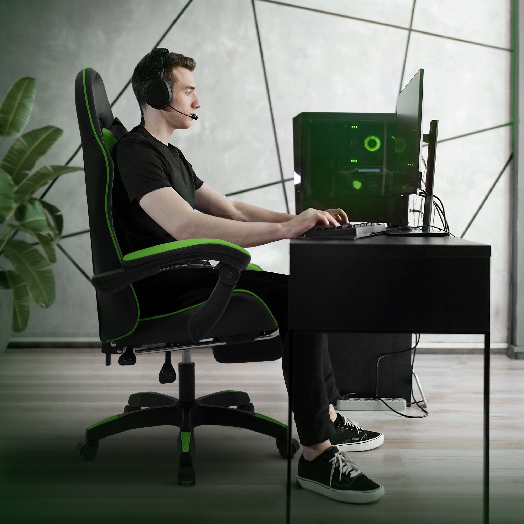 Junger Mann mit Headset sitzt an Schreibtisch und nutzt Gaming-PC.