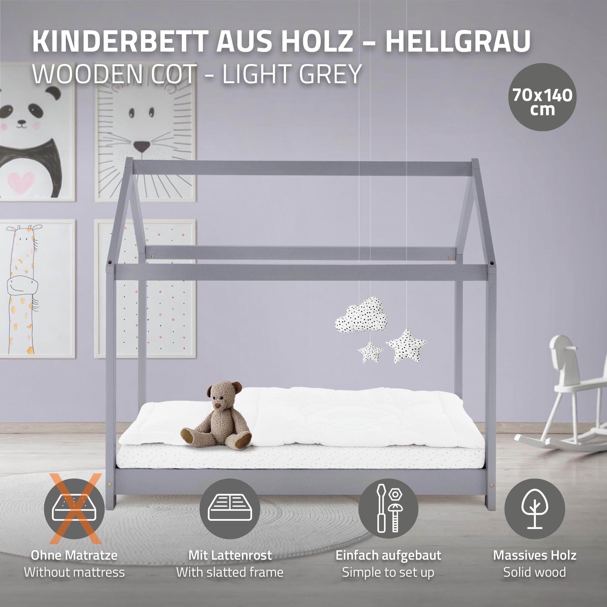 Lit d'enfant en bois gris clair avec matelas et jouet, contre un mur avec des images.