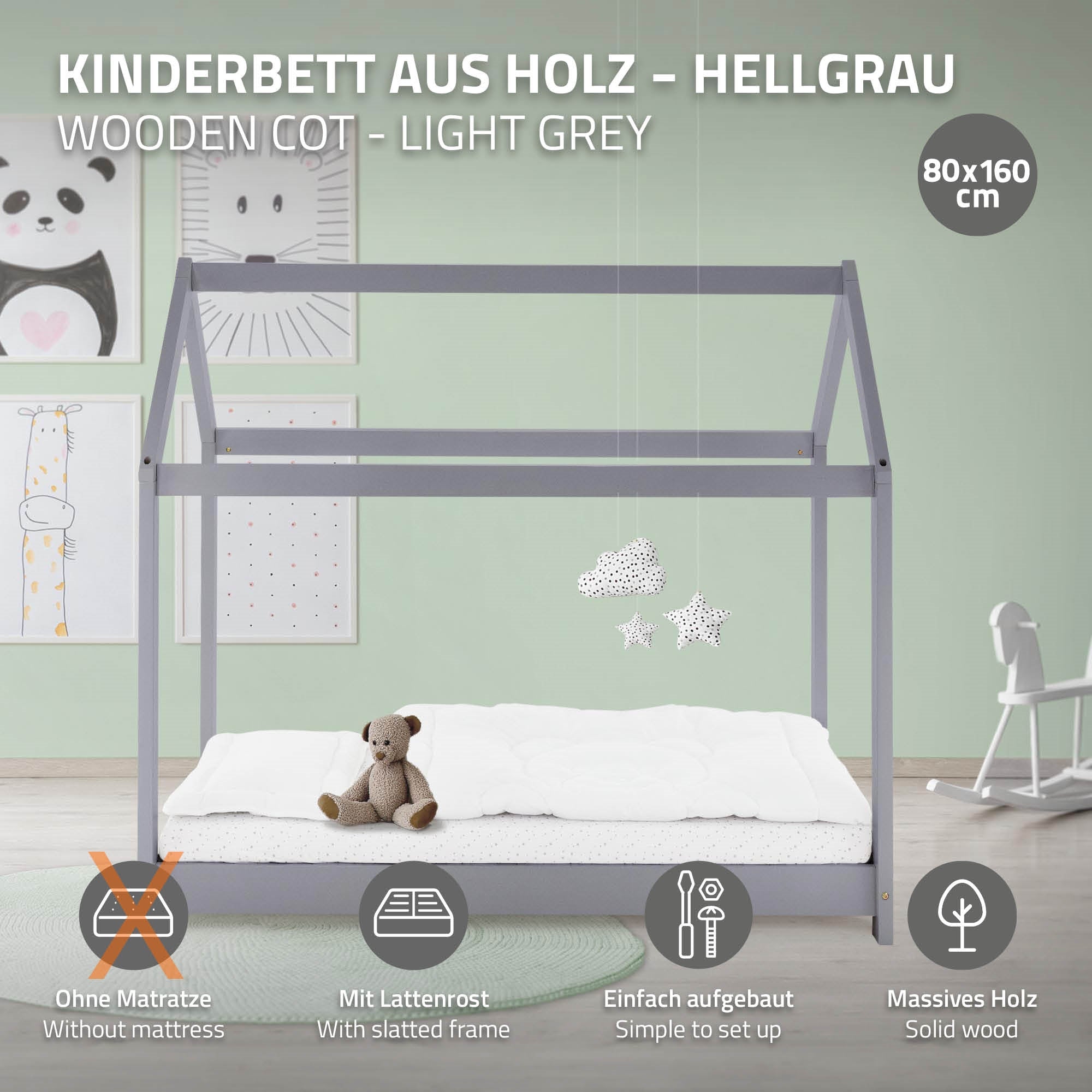 Lit d'enfant en bois gris clair avec un ours en peluche et des pendentifs en forme d'étoile.