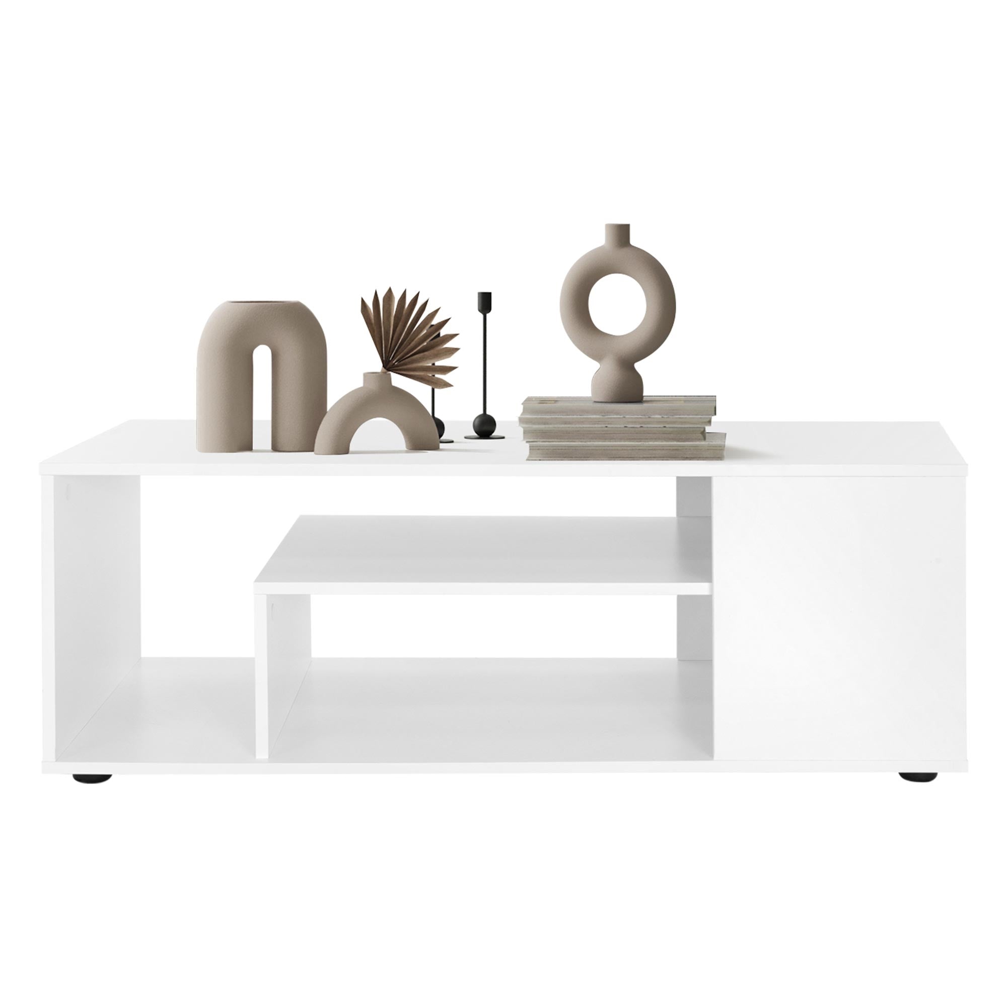 Mesa de café blanca con objetos decorativos y una pila de libros.