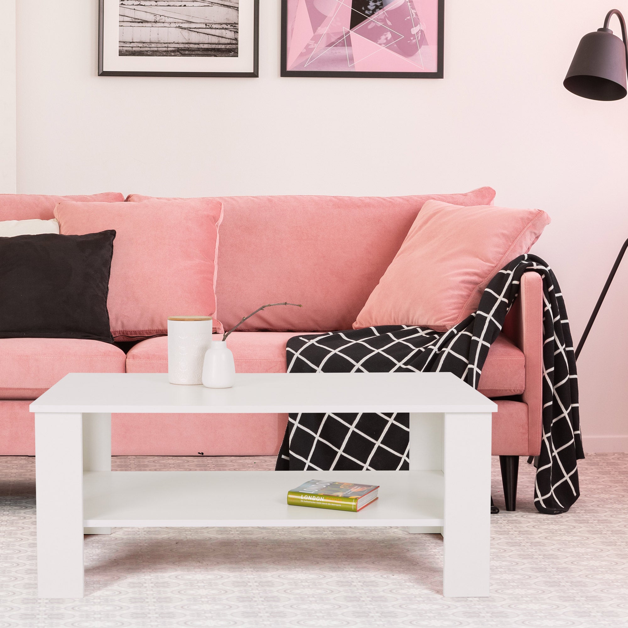 Rosa Sofa mit Kissen und einem weißen Tisch im Wohnzimmer.