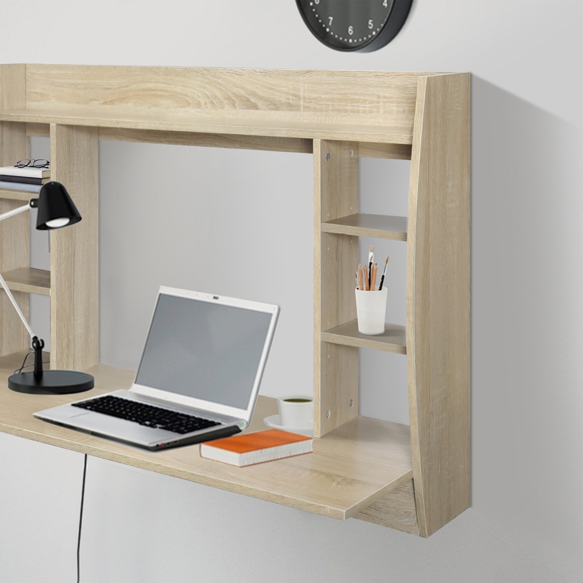 Scrivania in legno di colore chiaro, con laptop e lampada da scrivania.