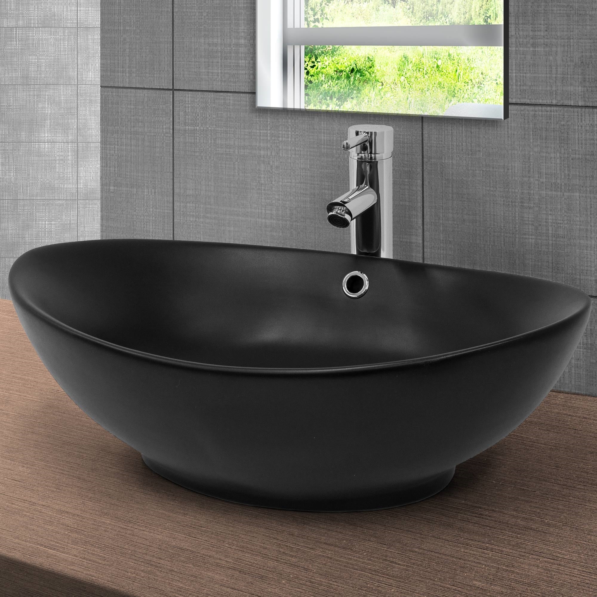 Lavabo negro y ovalado sobre una base de madera con espejo.