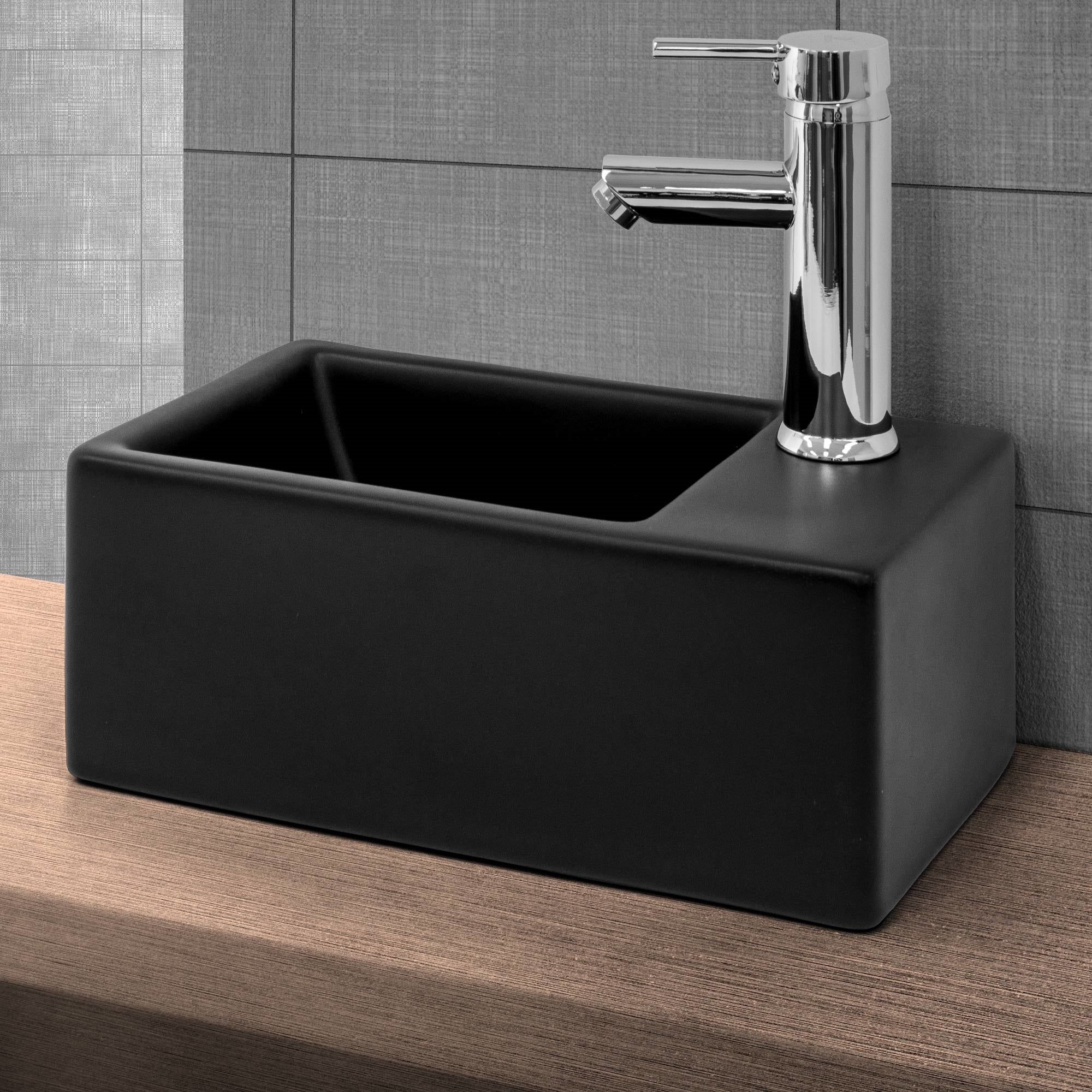 Rectangular black sink on a wooden surface.