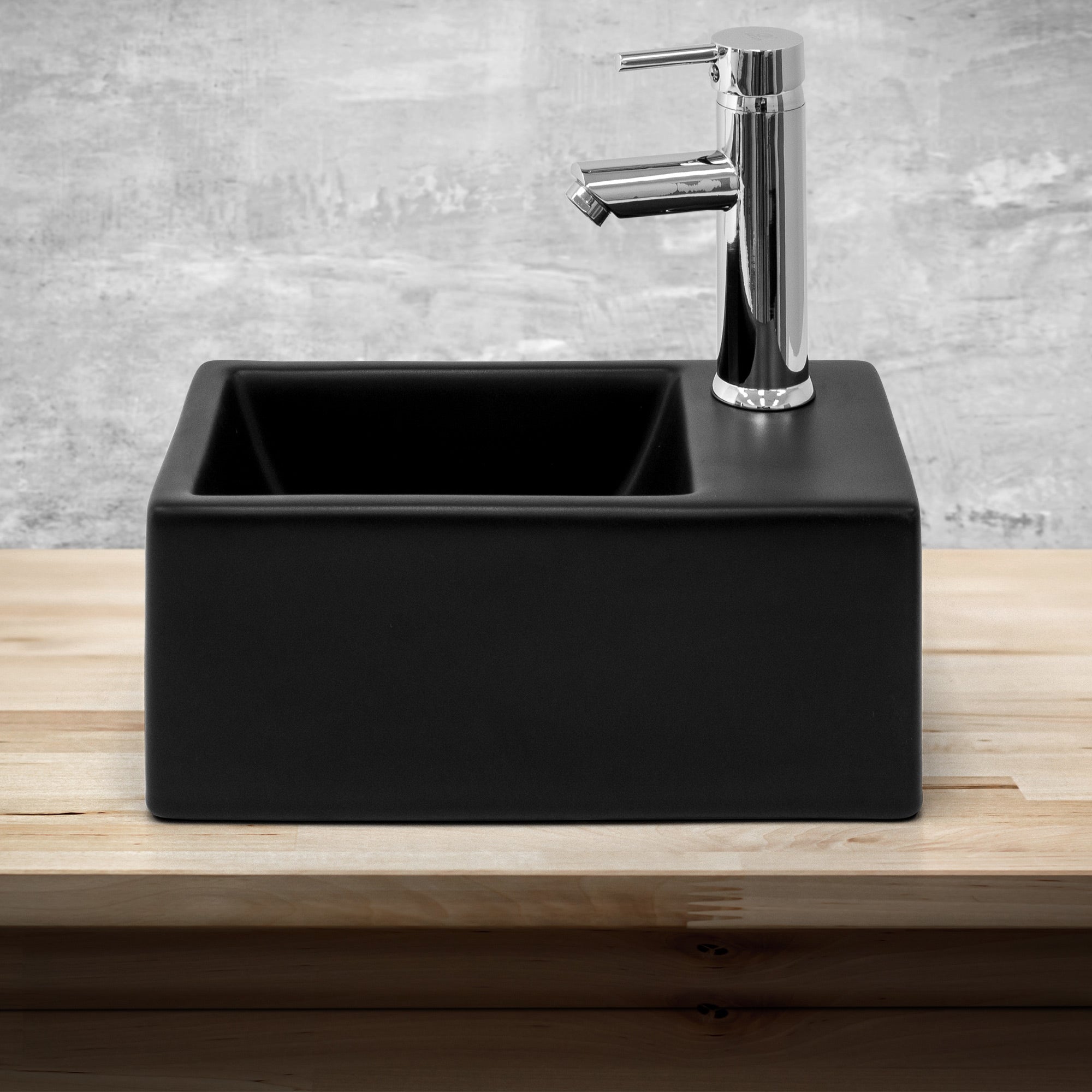 Black square sink on a wooden base.