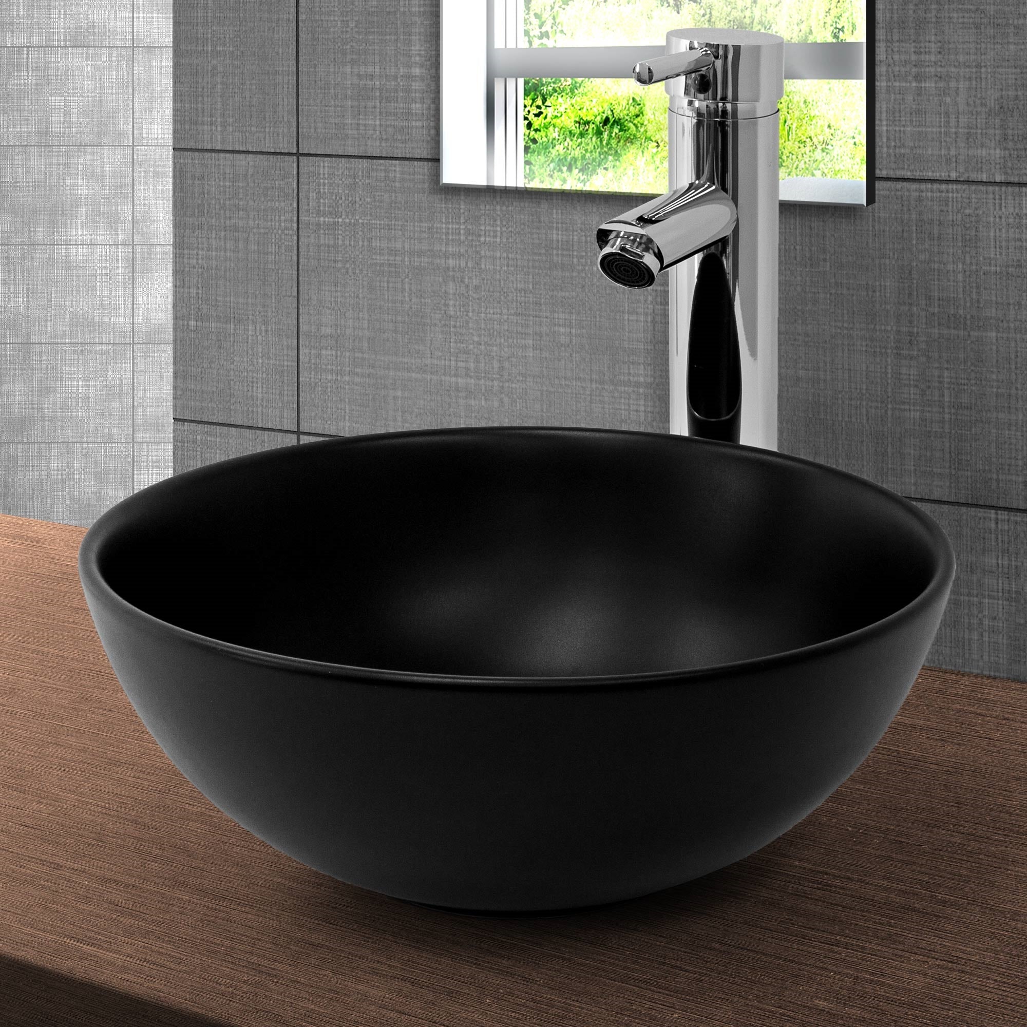 Lavabo redondo negro sobre una superficie de madera.