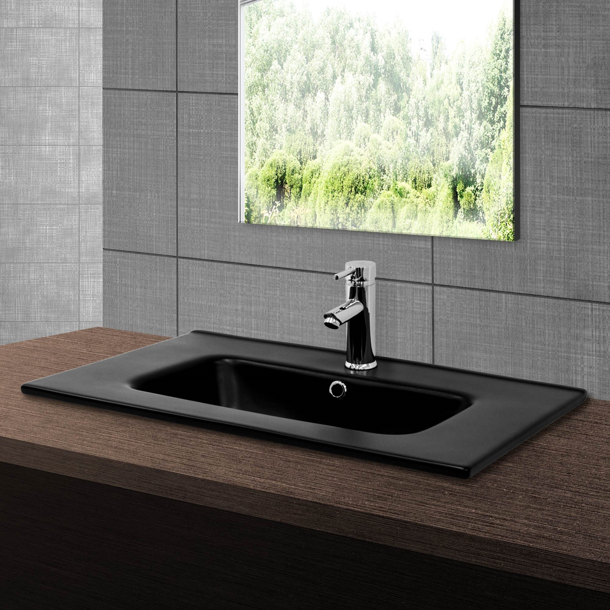 Lavabo nero con rubinetto davanti a una finestra.