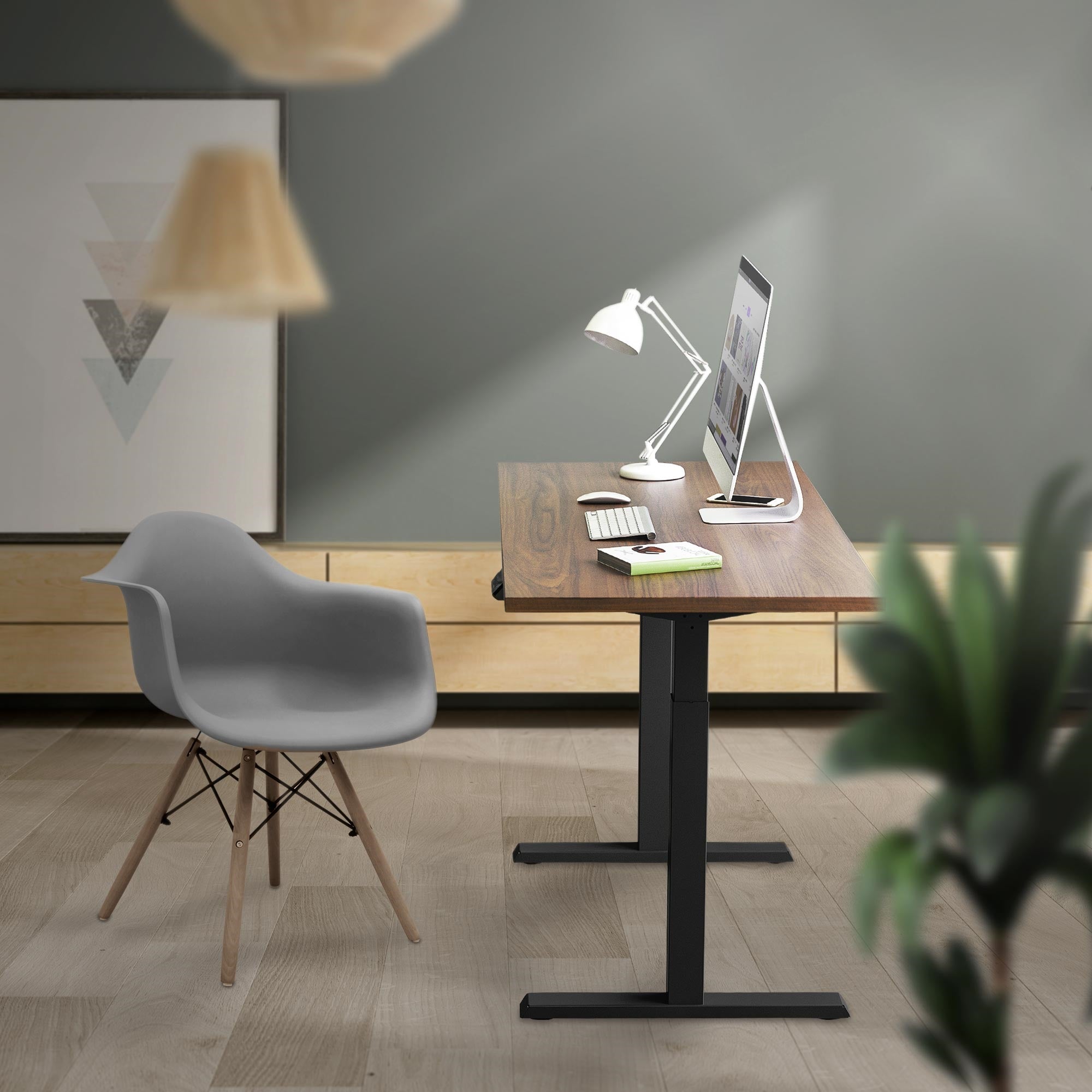 Lugar de trabajo con mesa de pie, computadora y silla gris.