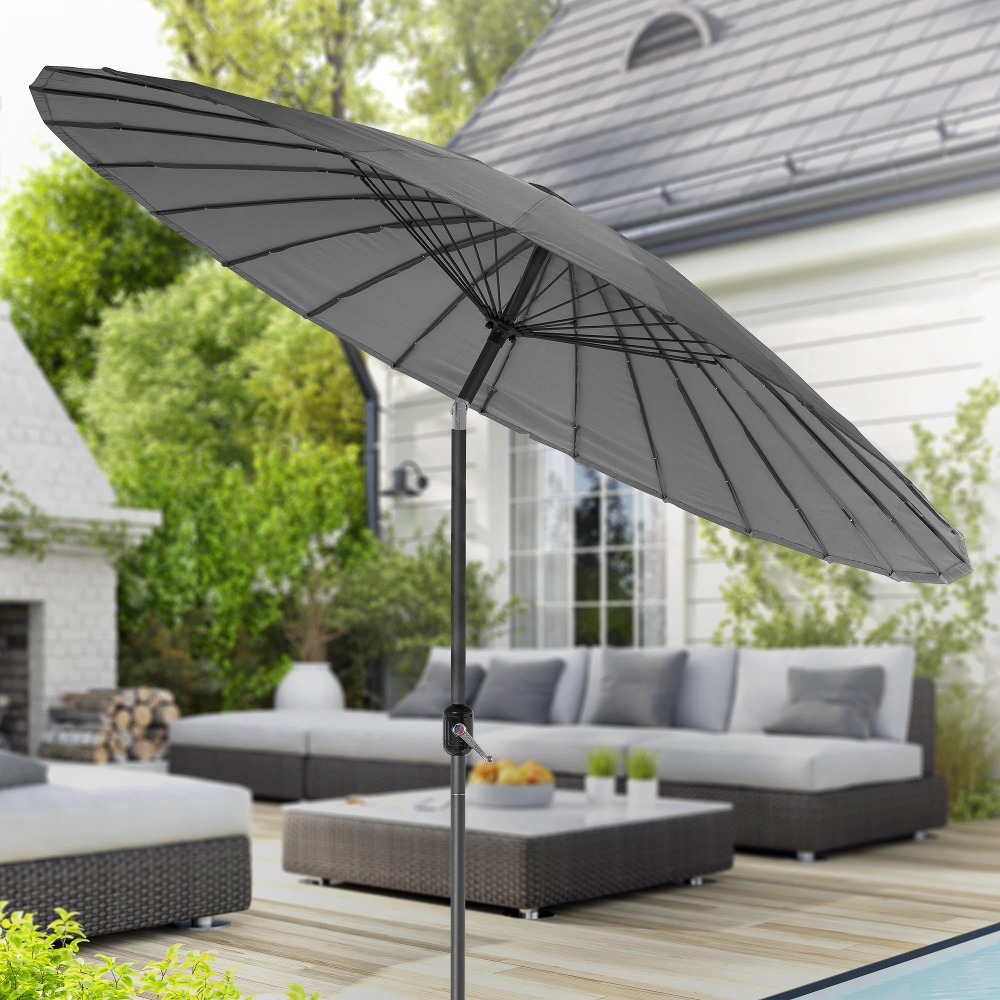 Vue de jardin avec un parasol gris et un coin salon confortable.