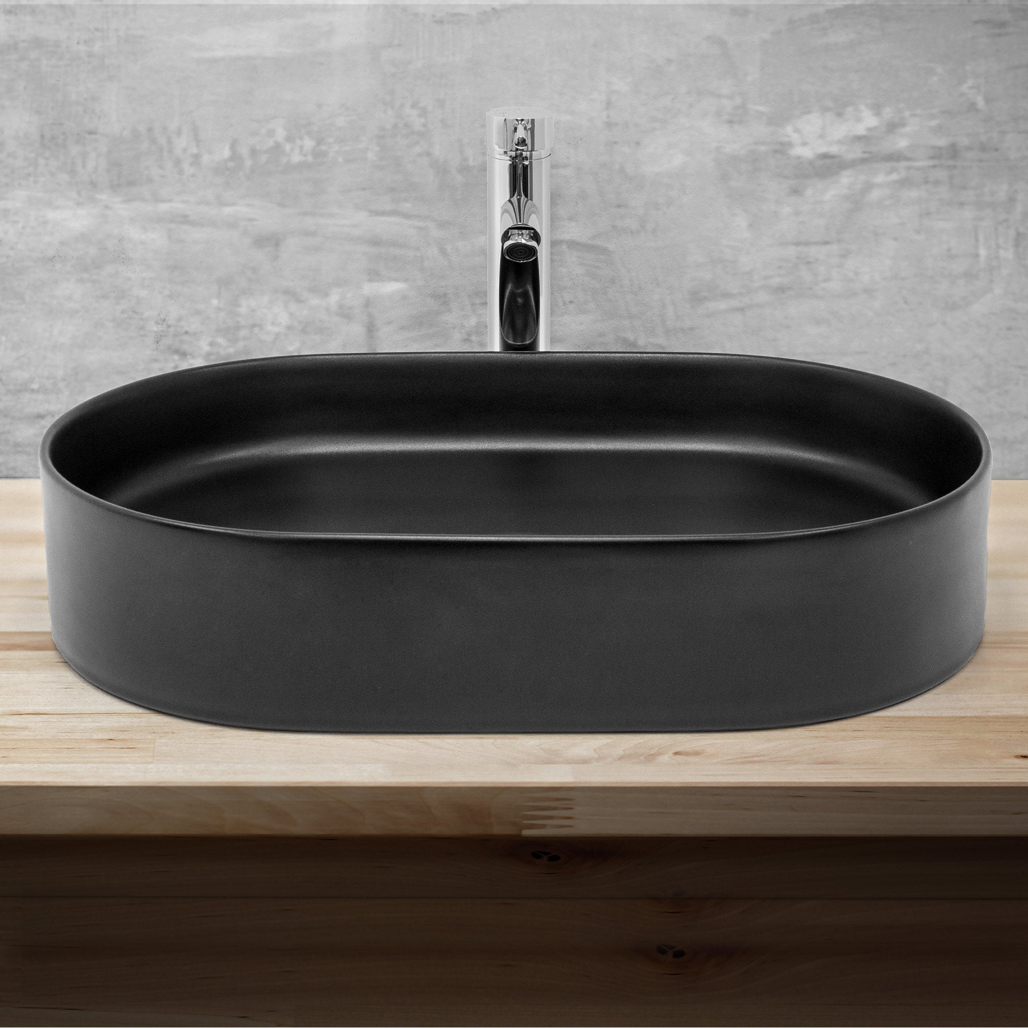 Zwarte, ovale wastafel op een houten oppervlak met kraan.
