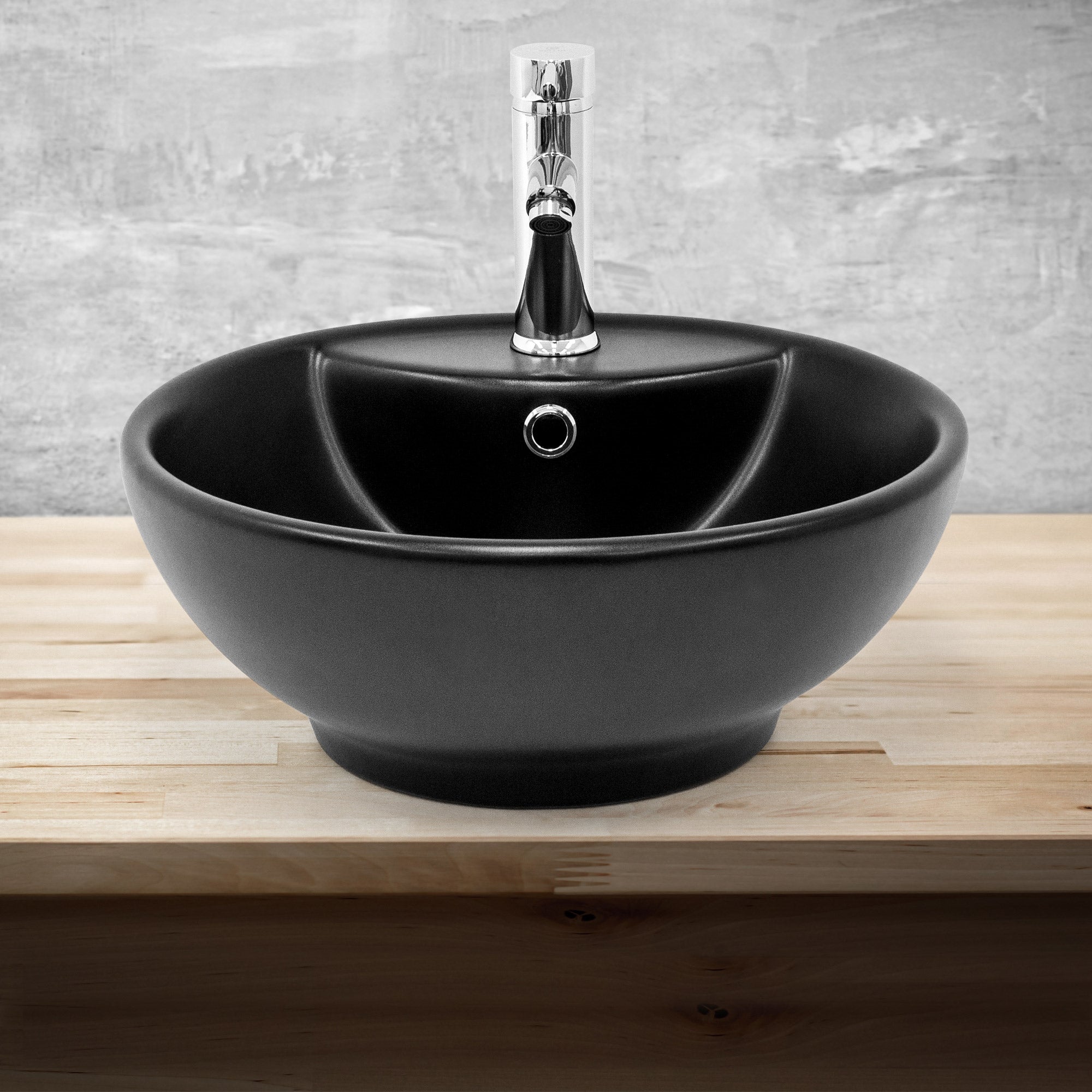 Lavabo negro con un grifo brillante sobre una superficie de madera.