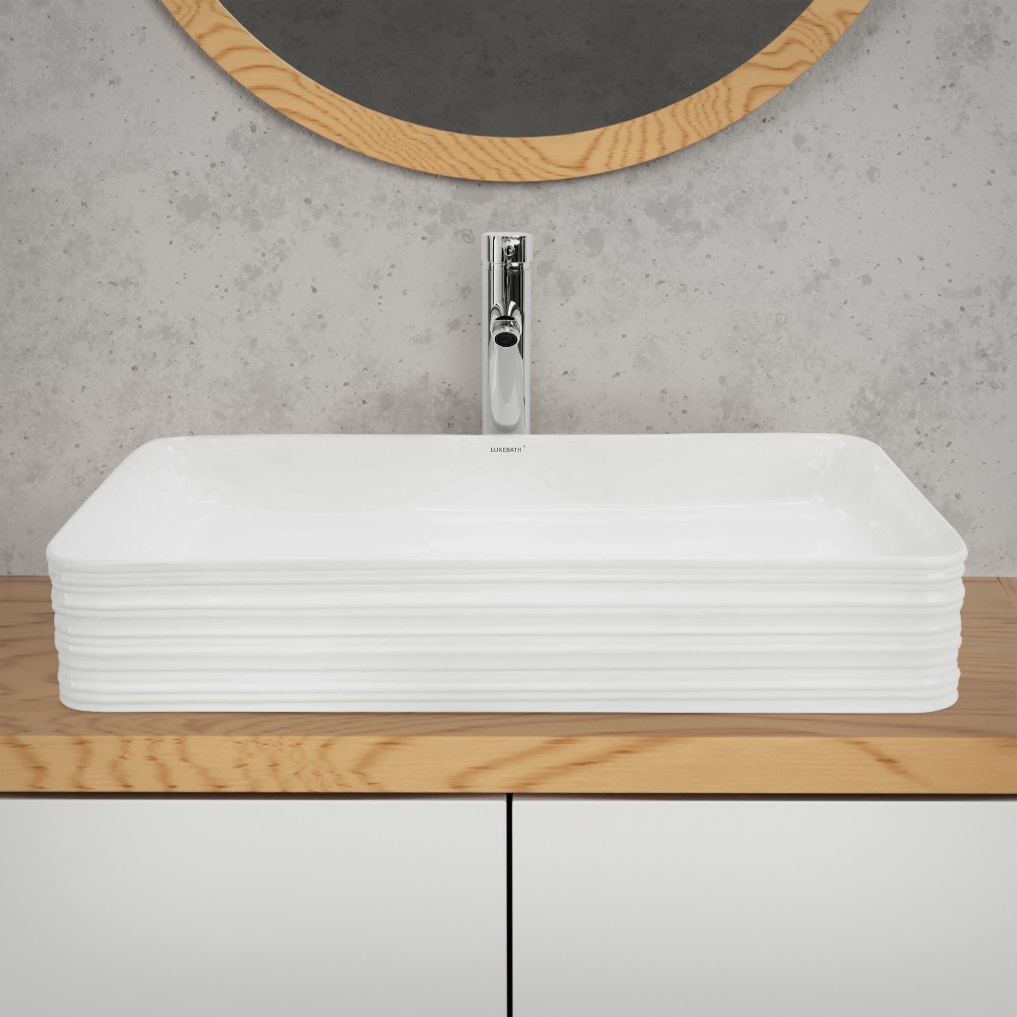 Évier rectangulaire blanc sur une étagère en bois devant un miroir.