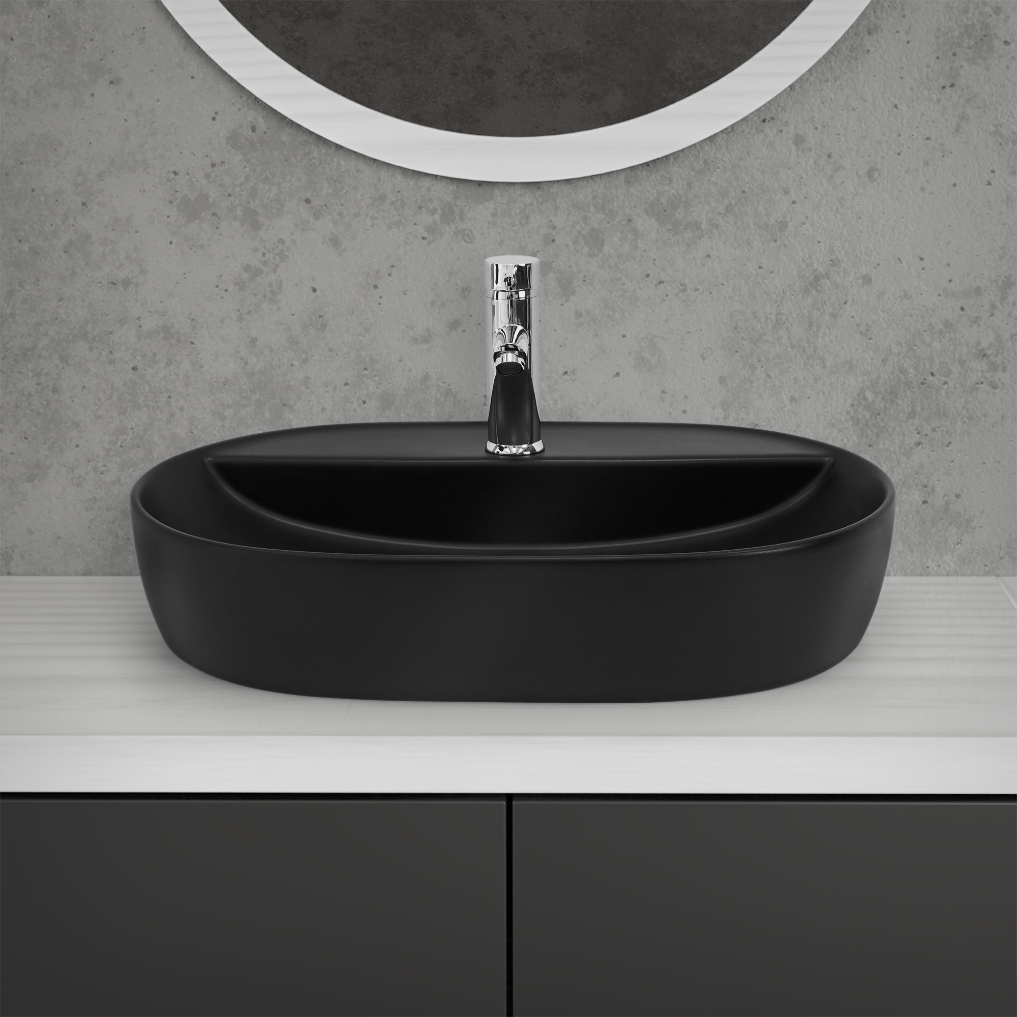 Schwarzes, ovales Waschbecken auf einem weißen Tisch mit Wasserhahn.
