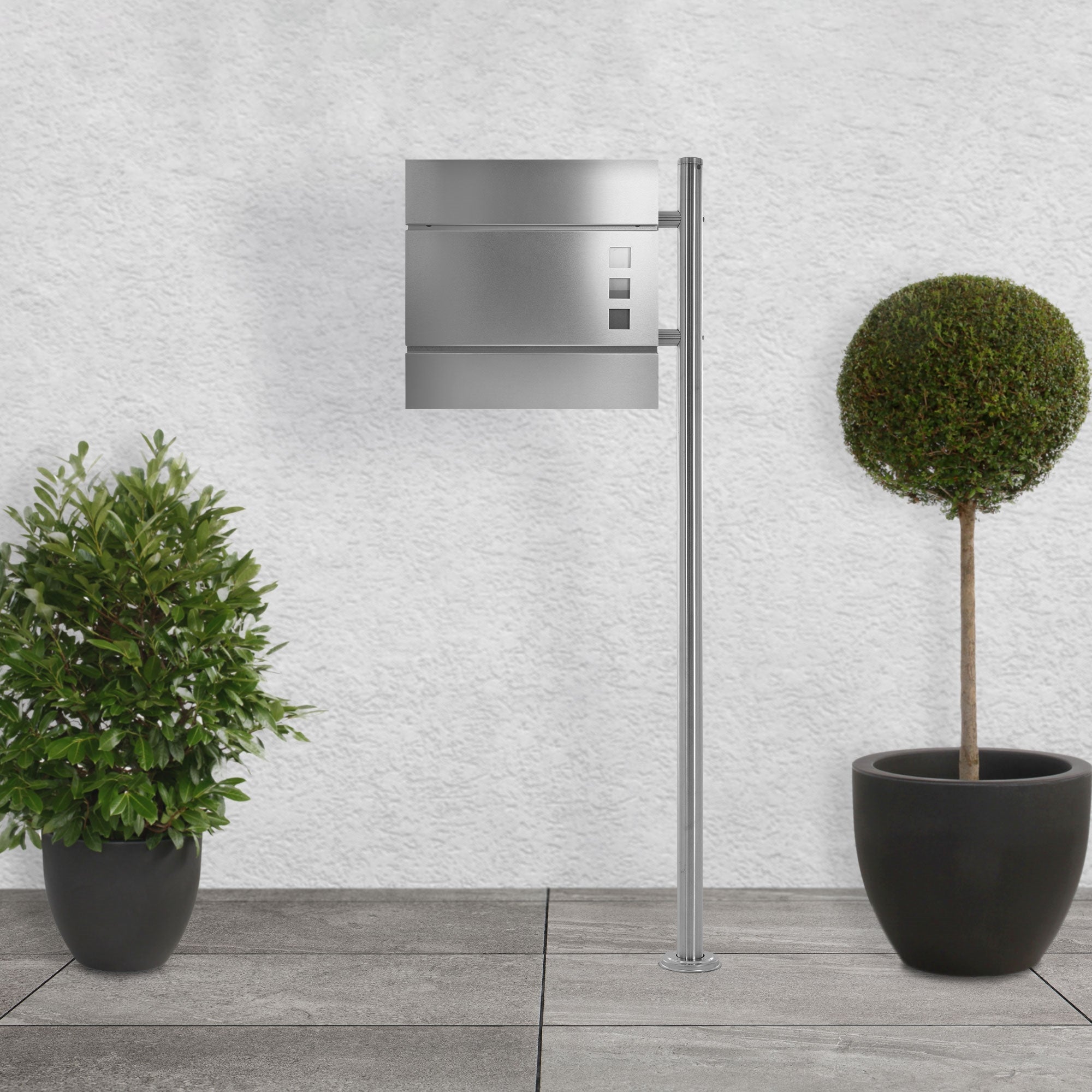 Metal mailbox stand with a mailbox and two potted plants.